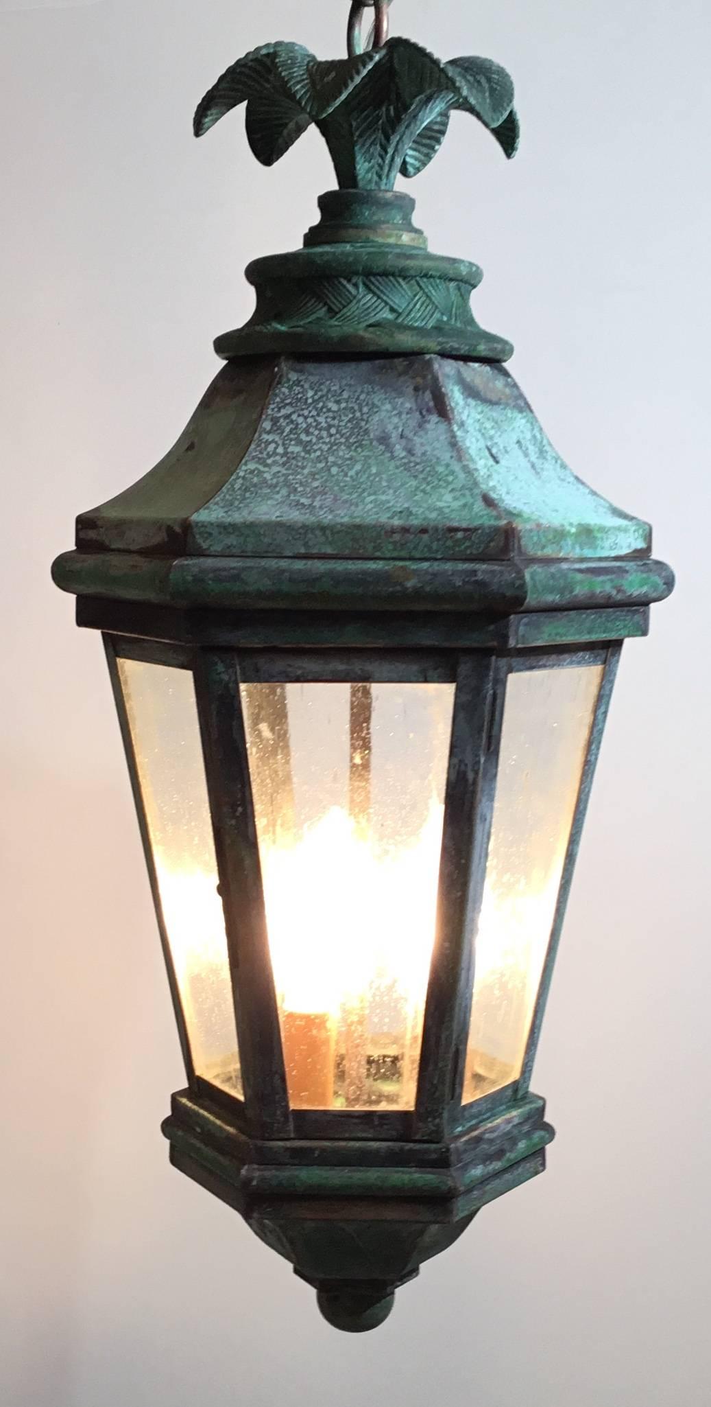 Funky  lantern made of hand crafted solid brass ,bronze top with decorative palm leaf motif ,weathered  patina ,electrified with three 40/watt lights,good for wet locations and would look great indoor as chandelier.seeded glass.