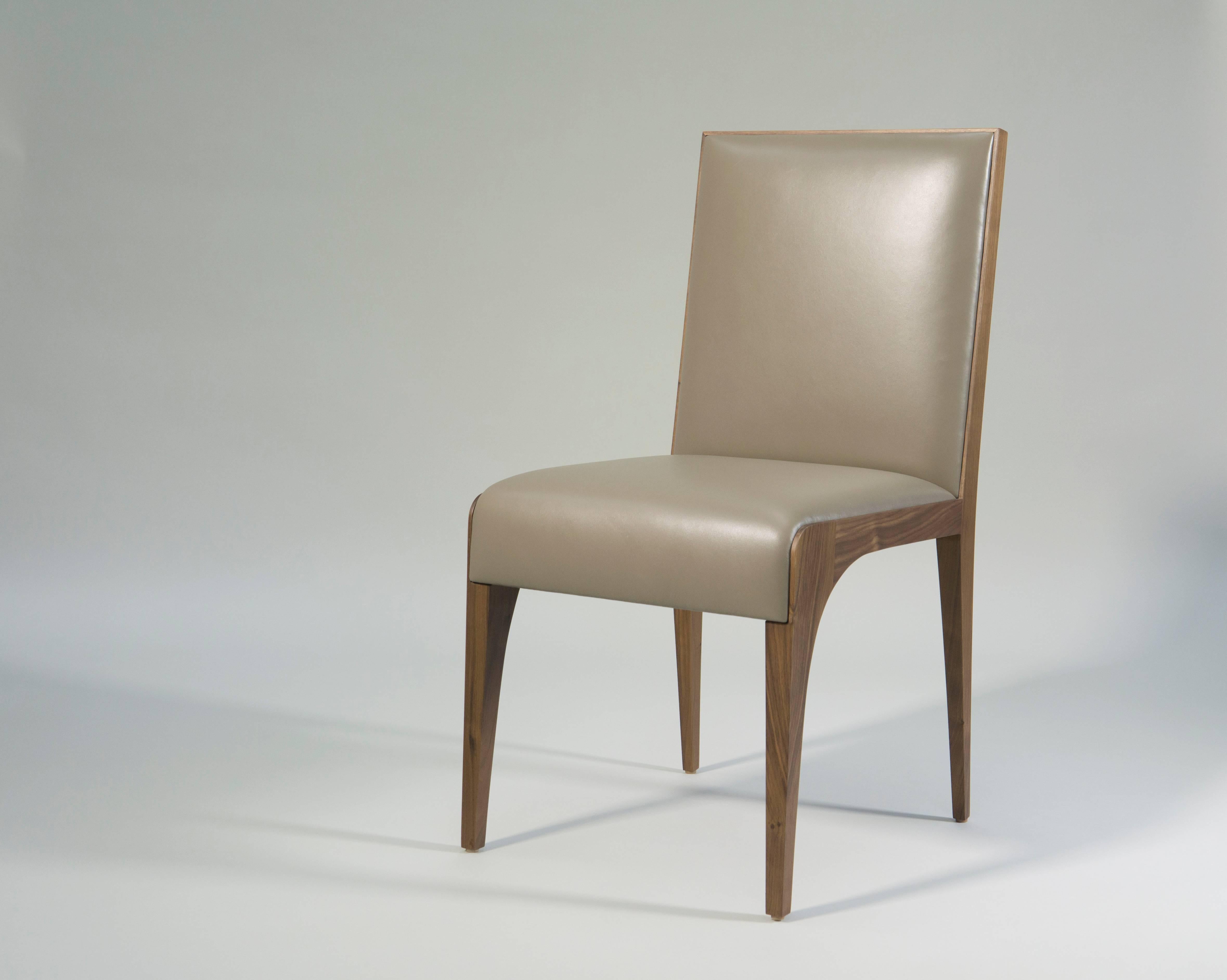 A pair of elegant dining or side chairs by Tinatin Kilaberidze.

Made of her favorite walnut wood and upholstered in leather, their beautiful form and fine craftsmanship make these chairs timeless.
The dining chairs can be ordered with fabric or