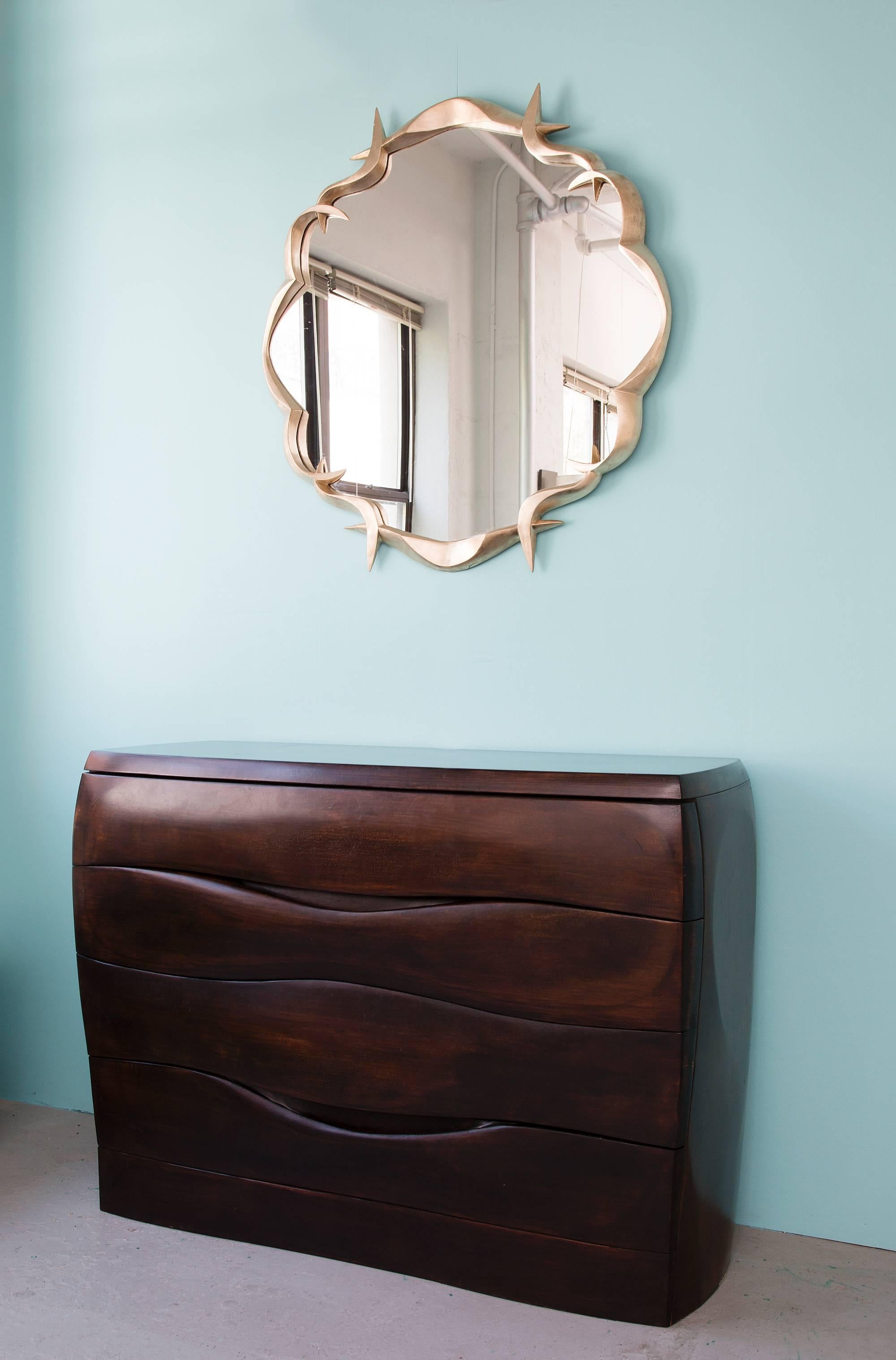 This elegant, finely crafted mirror is made in bronze and gold leafed. 

Anasthasia Millot has learned to translate into bronze the fluidity of preferred textiles like jersey, creating subtly dynamic shapes that seem to defy the statics of solid