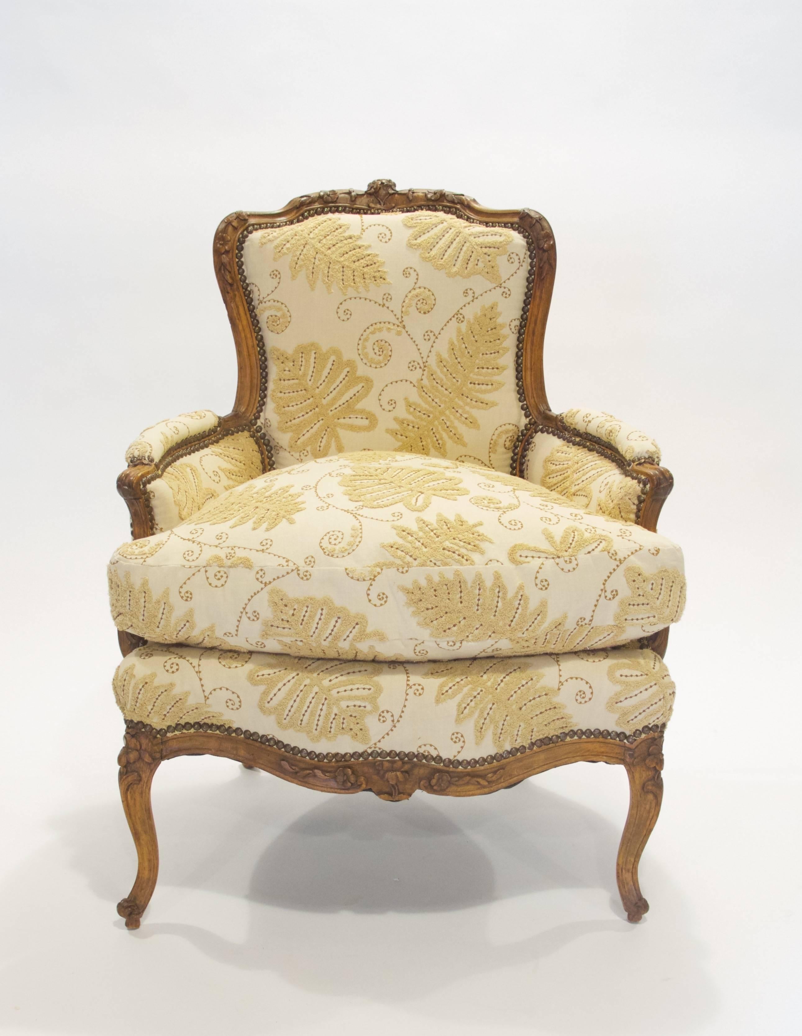 This French, Louis XV period beechwood armchair (bergère) has a shaped back with carved floral motifs, raised on cabriole legs. The bergère was formerly in the collection of the Phipps family, Long Island.