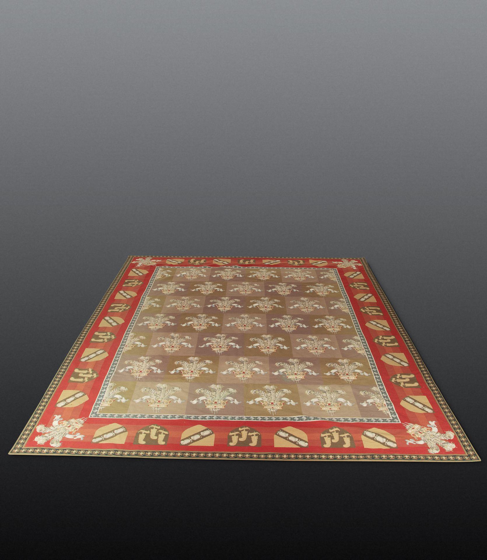  Un grande tappeto decorativo ad arazzo della fine del XIX secolo, con centro a scacchiera e piume del principe di Wales, all'interno di un bordo rosso con scudi araldici e ulteriori piume agli angoli. In buone condizioni, circa 1870.

W: 364 cm