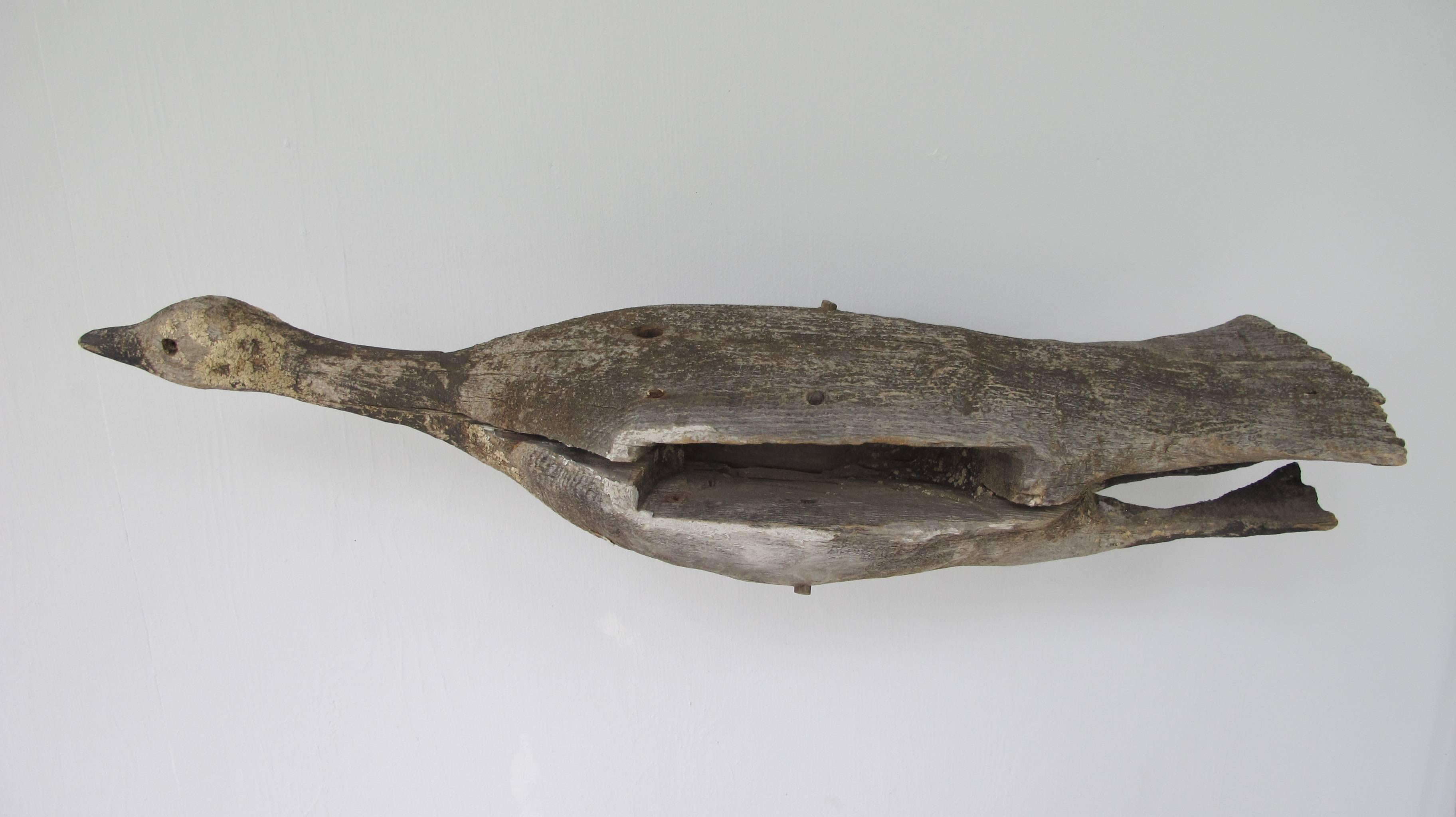Flying Canada goose carving with extended neck and legs pulled up in the back.
There is a hole in the bottom where it was attached and used as a weathervane or trade sign. It had wings that would have slotted into the sides and were pegged. Without
