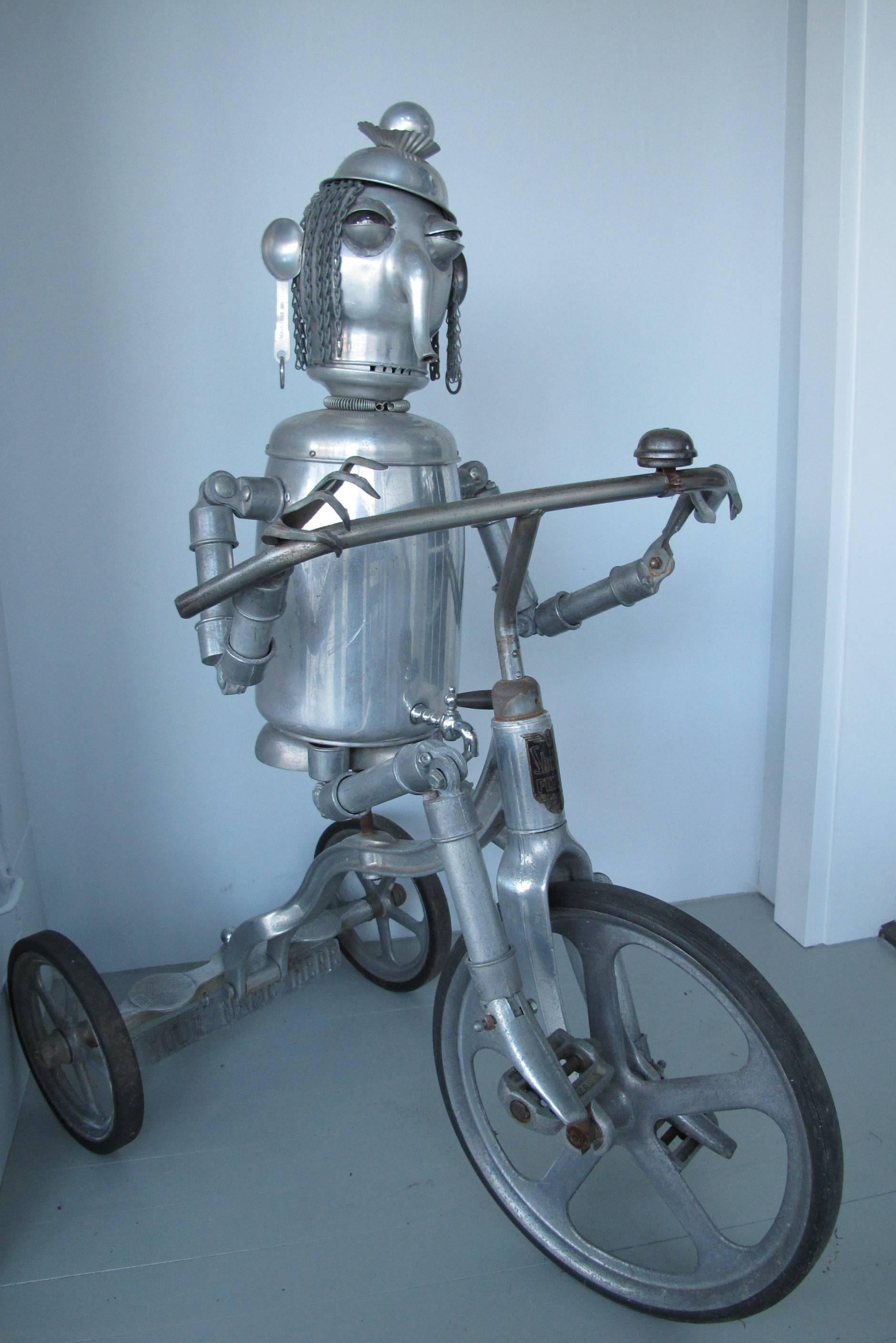 Jim Bauer is a self taught artist who creates compelling Robots and figures from all manner of aluminum objects that he has collected. This is one of his most 
ambitious sculptures using a vintage tricycle. The robot has dreadlocks of fine chain