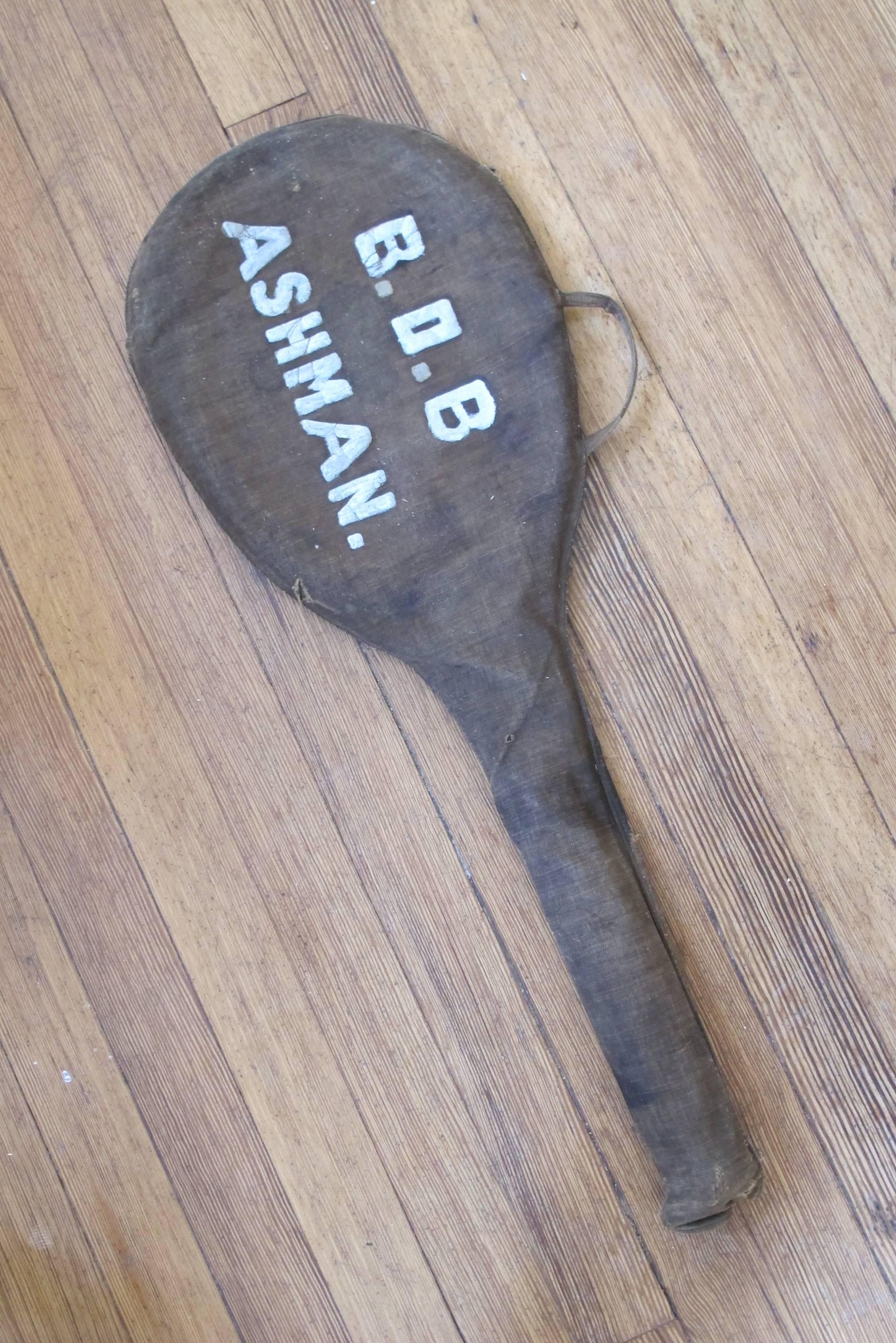 Tennis racquet with canvas cover with painted warning on top. 