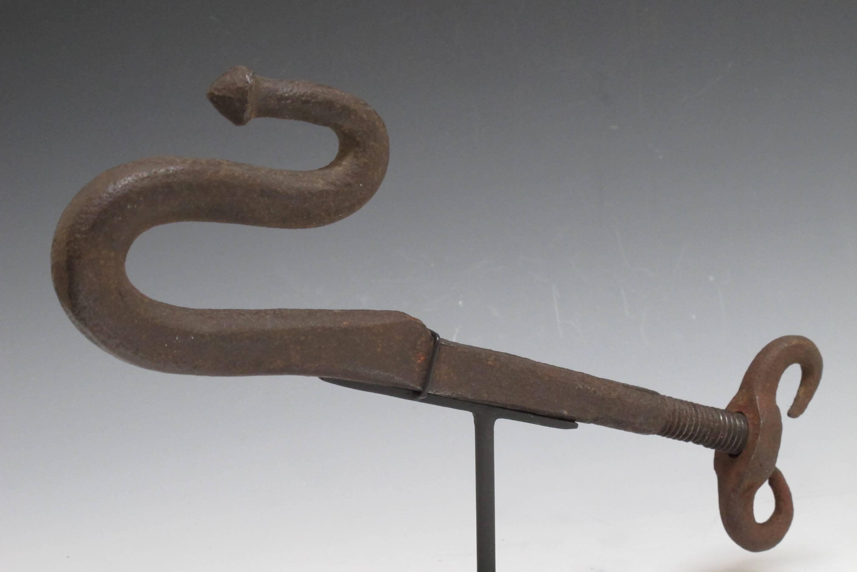 Blacksmith forged iron snake form hook made  to mount on a conestoga wagon 
to hold provisions on the journey west.The hook goes into a square shaft which was threaded at the end to receive a winged nut. From the famed Sorber collection of early