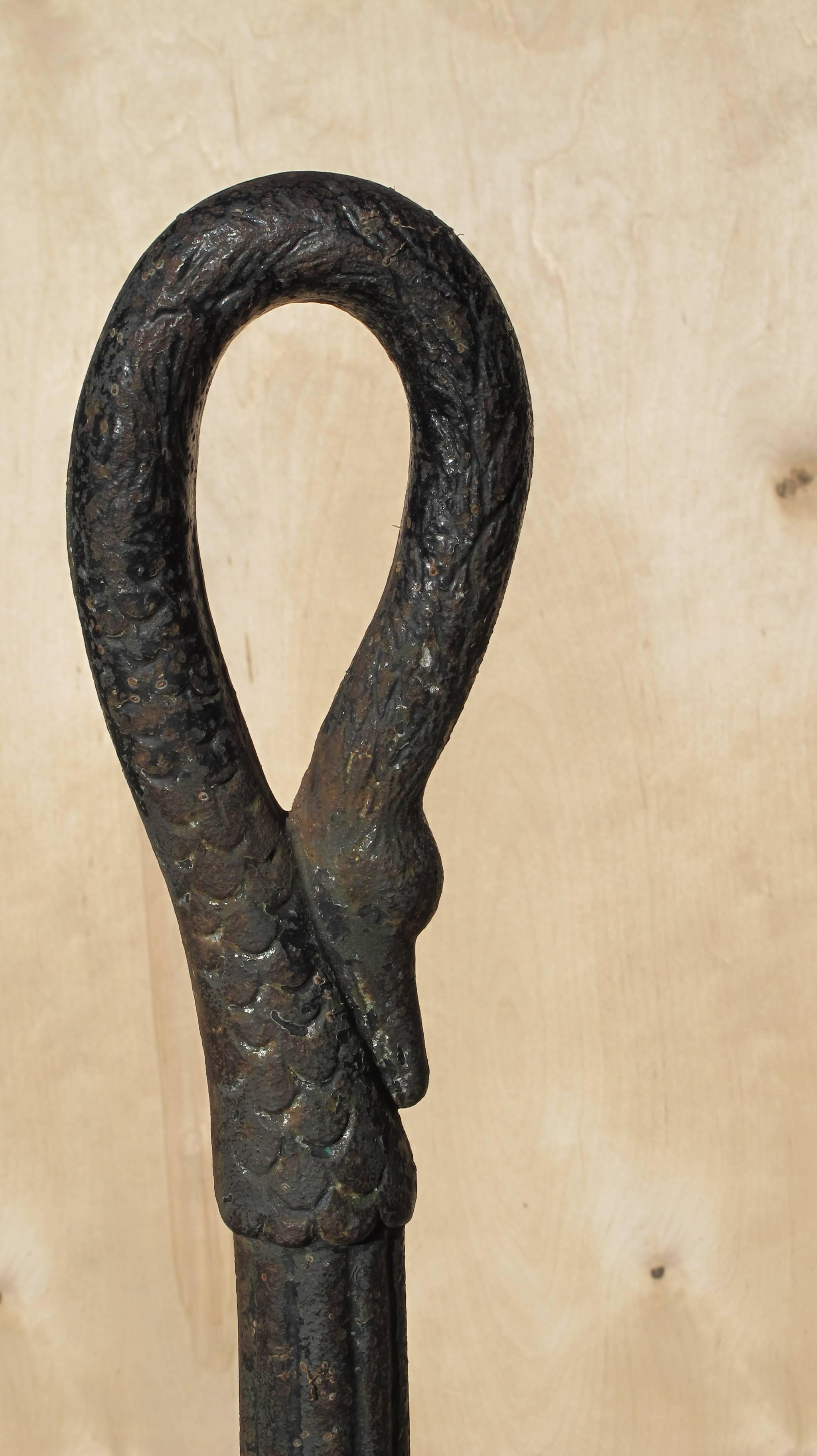 Elegant form in this 19th century hitching post to tie up horses. The artistry of this swan's neck includes striations of feather lines and details to the head. The lower shaft is grooved with rhythmic rings and nice aged surface with old paint.