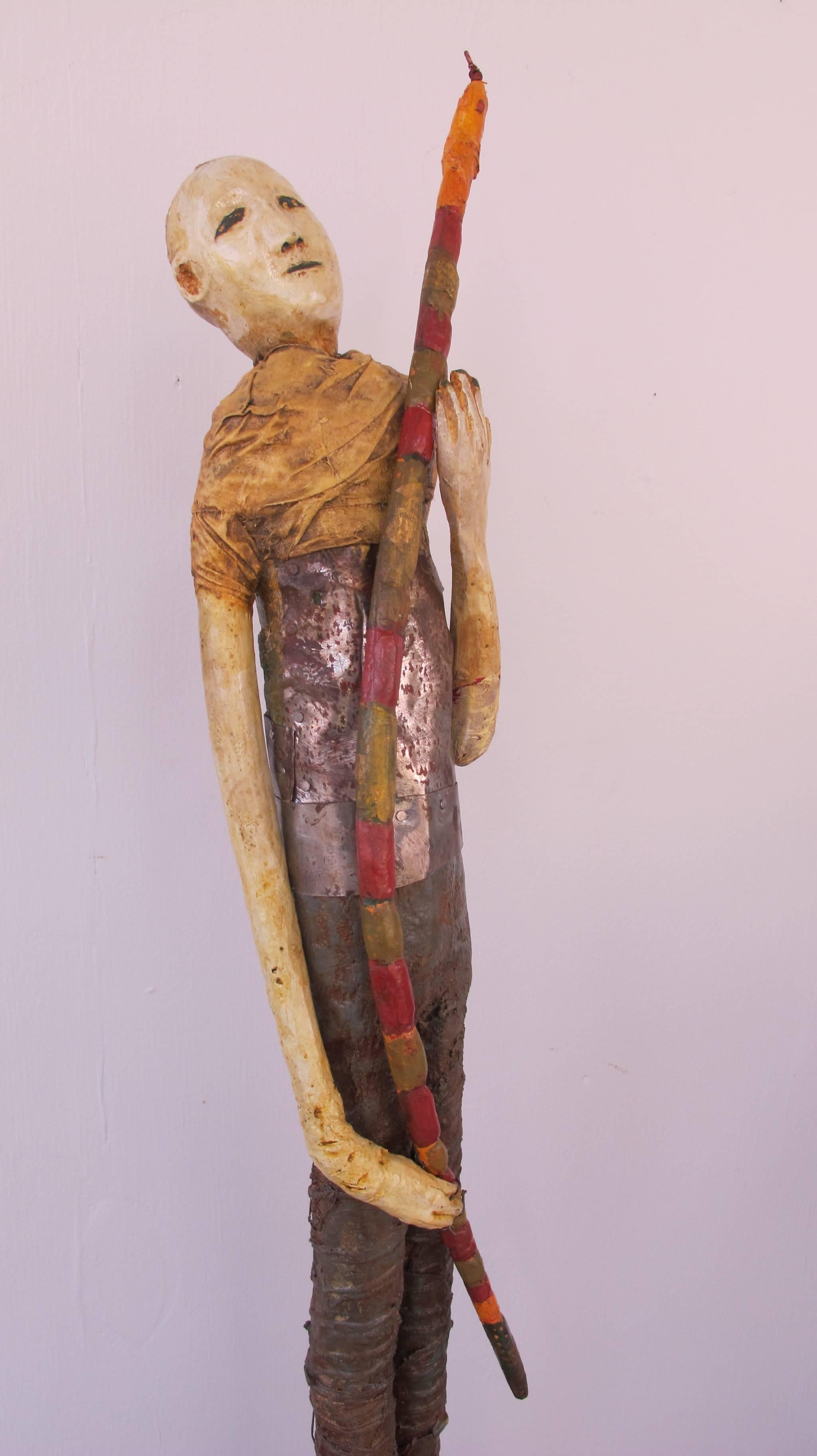 Self-taught artist Terry Turrell carved and painted wood and tin figure with cloth wrapping. The figure is holding a banded wood snake with a metal tongue.