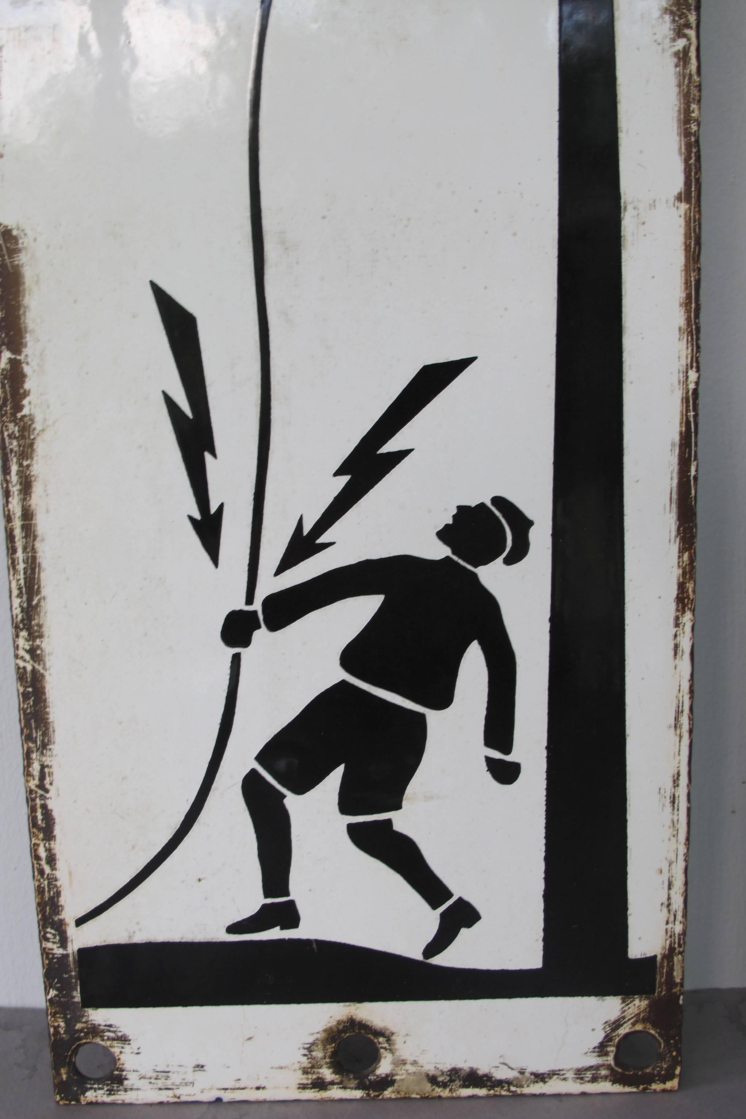 Two enameled iron warning signs with images of man grabbing a downed electrical wire with bold black skull and crossbones above. The quality of the graphic images blows me away. The signs have holes at the top and bottom for attachment probably to a