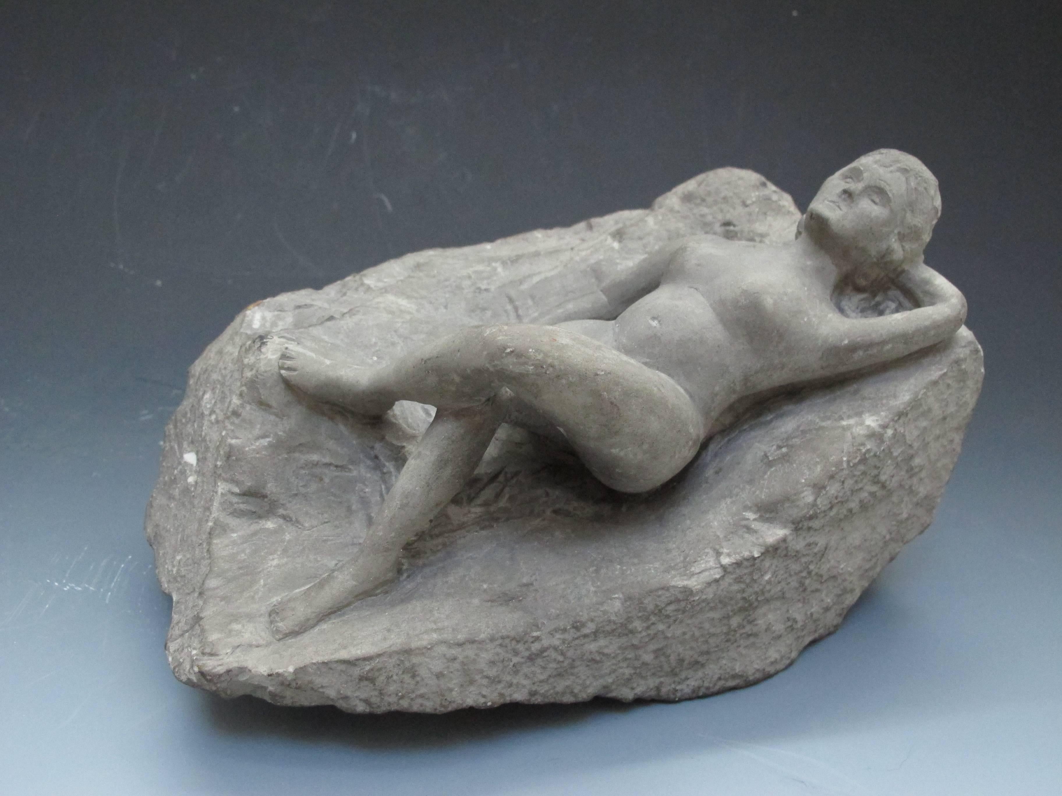 Finely carved reclining woman on rough stone by unknown carver.