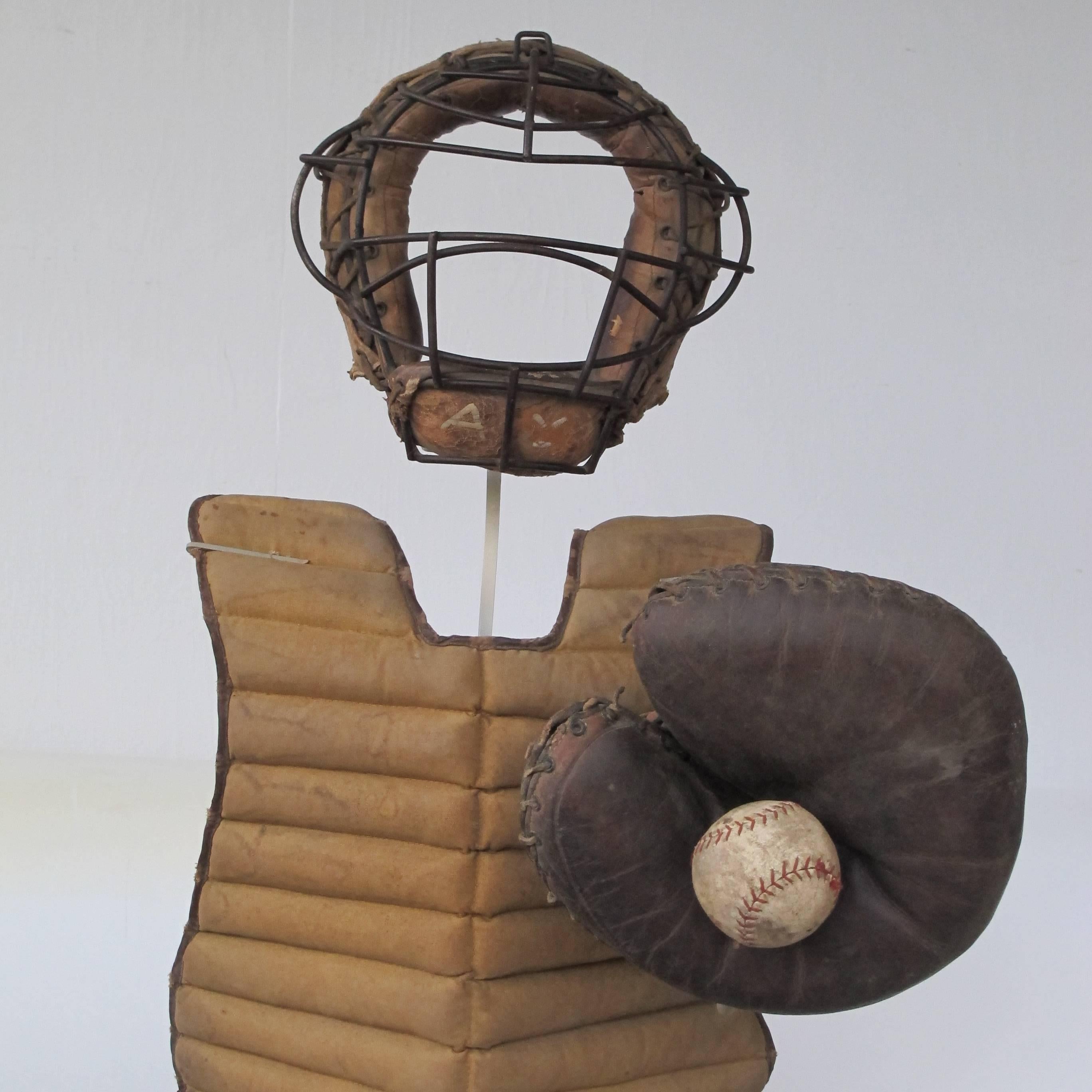 We have collected vintage baseball gear and assembled them over a metal base as an animated baseball catcher from the 1950s. All of the pieces are game worn with some patina and wear. The articulated mount allows movement of the mitt. All the