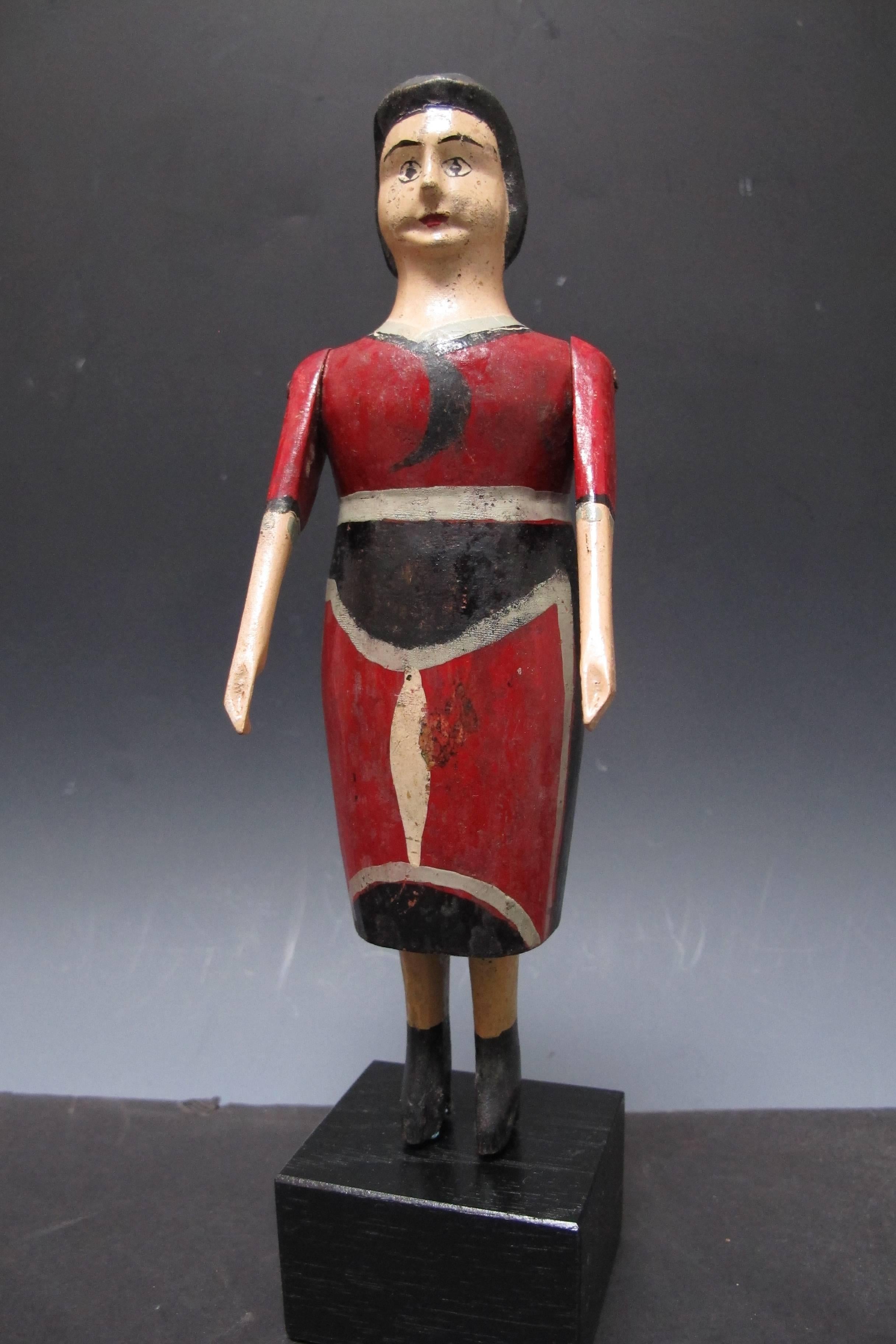 This anonymous folk sculpture is distinguished by the unusual dress painted in graphic abstracted style. The arms which are carved separately and fixed on with tacks are moveable. From a Pennsylvania collection. Mounted on a wood base.