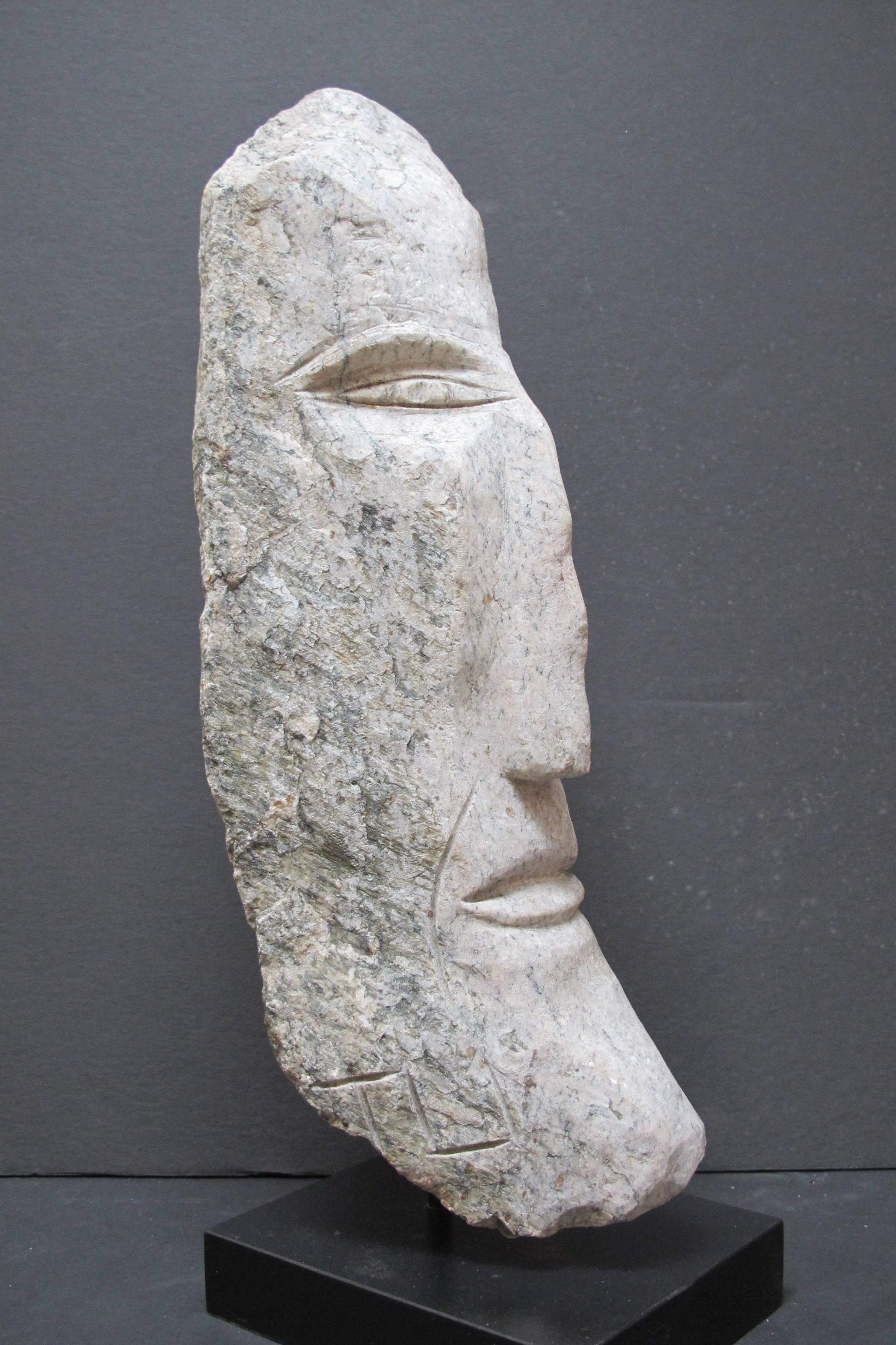 Ted Ludwiczak (1927-2016) was a self taught art who became known for his carved stone heads. He worked grinding hard contact lenses and after retiring he built a stone wall on his property. Seeing a face in one stone he took an iron lawnmower blade