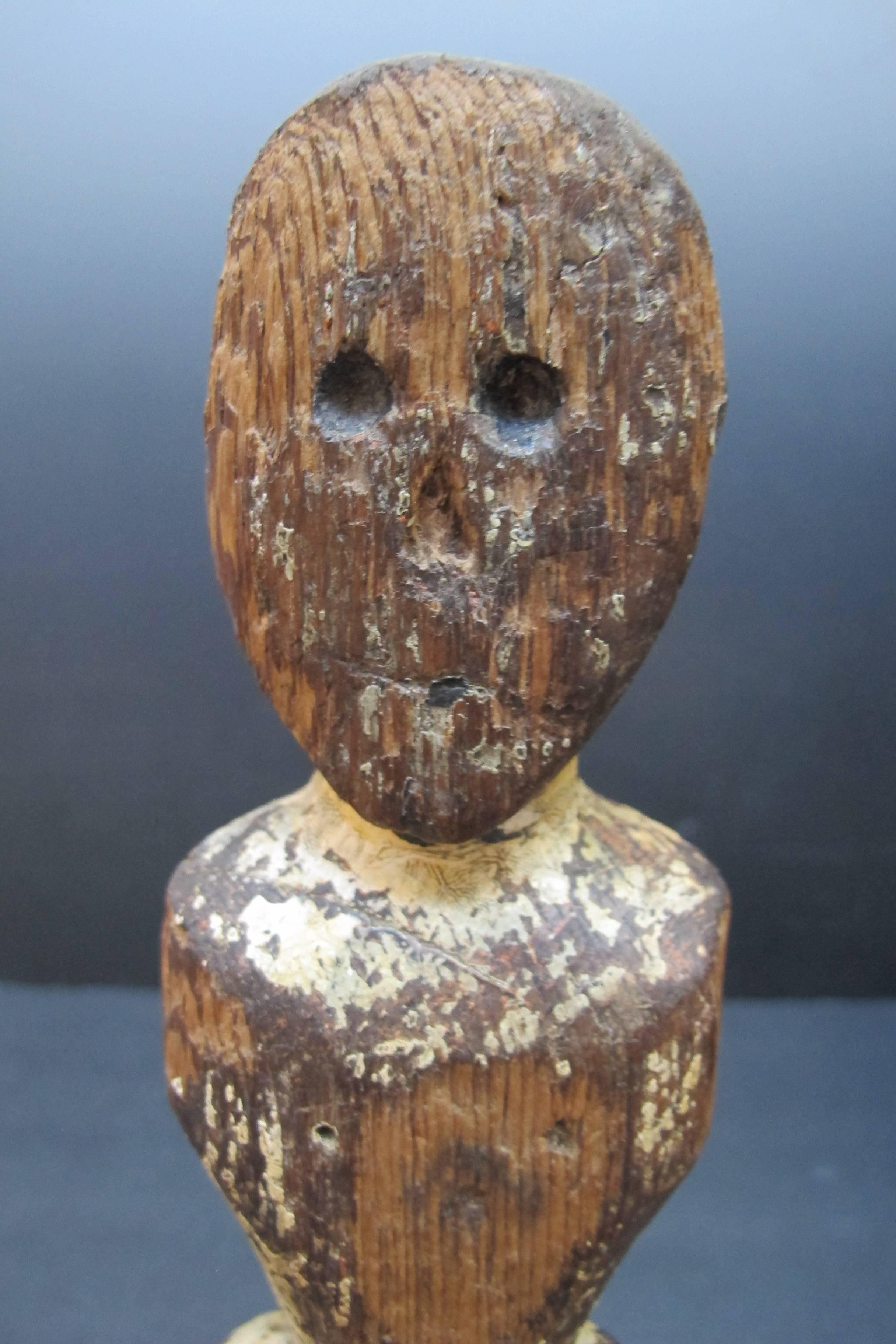 An early Pioneer doll of minimal form and remains of old paint. The head has hollowed out eyes which may have had inset eyes at one time. The wood is white cedar. The form is related to the wooden Queen Anne dolls of the 18th century and may have