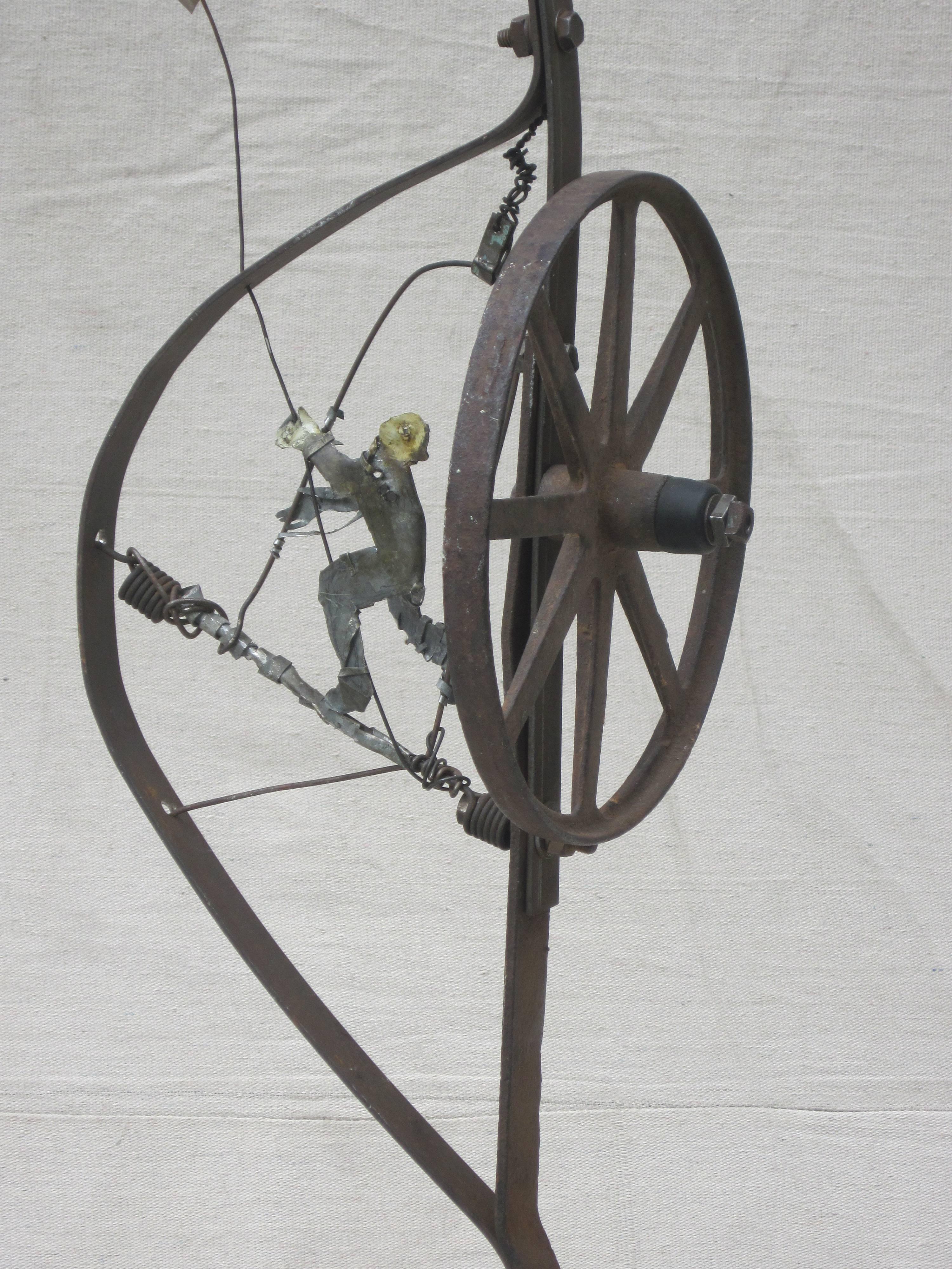 Terry Turrell is known for his paintings and sculpture made often using found materials incorporating figures and animals. In this piece the wheel is a repeated element relating to the figures as well as carrying the figures in the cart. Swing time