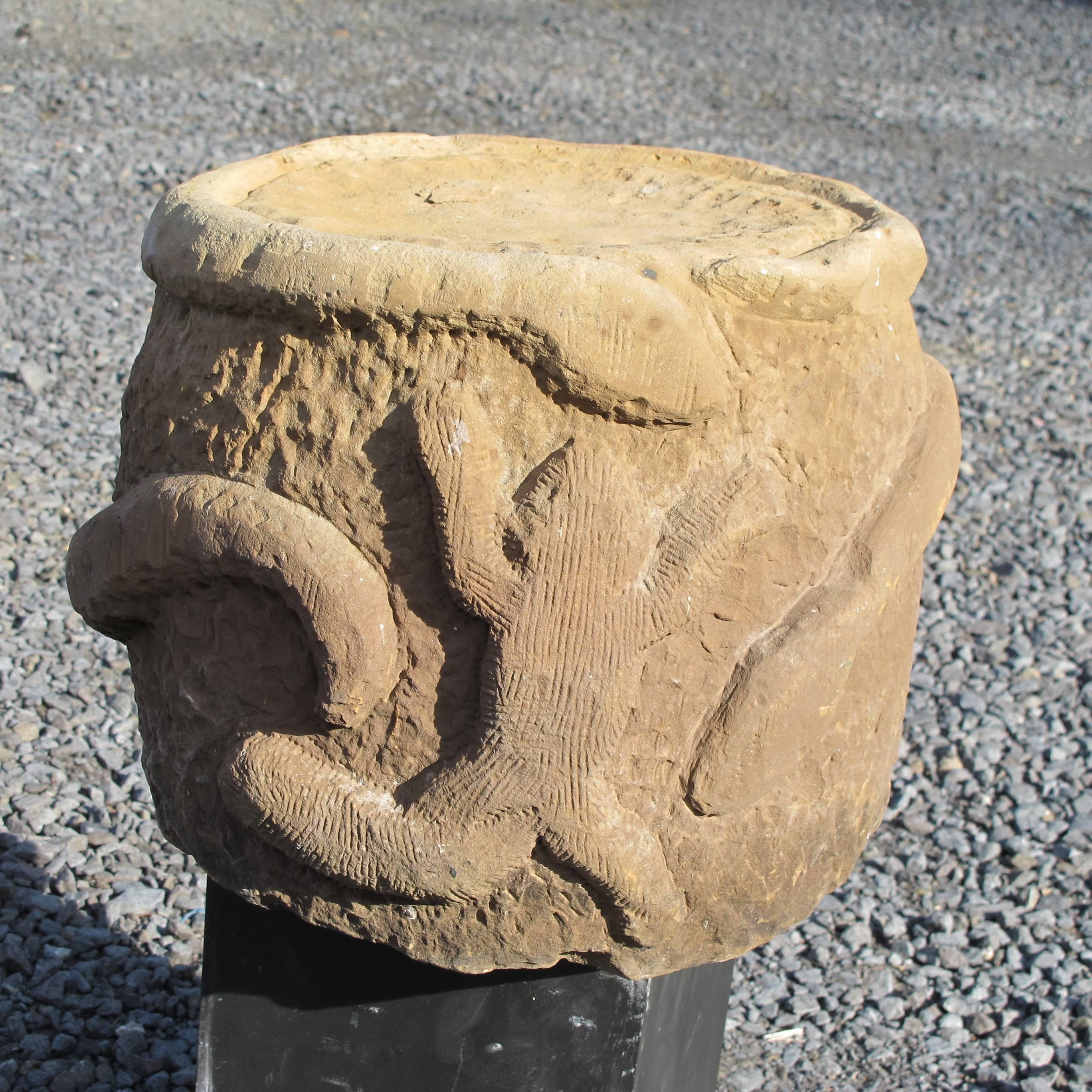 Unusual carved sandstone sculpture in the form of a stool with snakes and frog.
Unknown artist found in Philadelphia. Earth colored stone with textured surface.
Looks good as a stand for a plant.