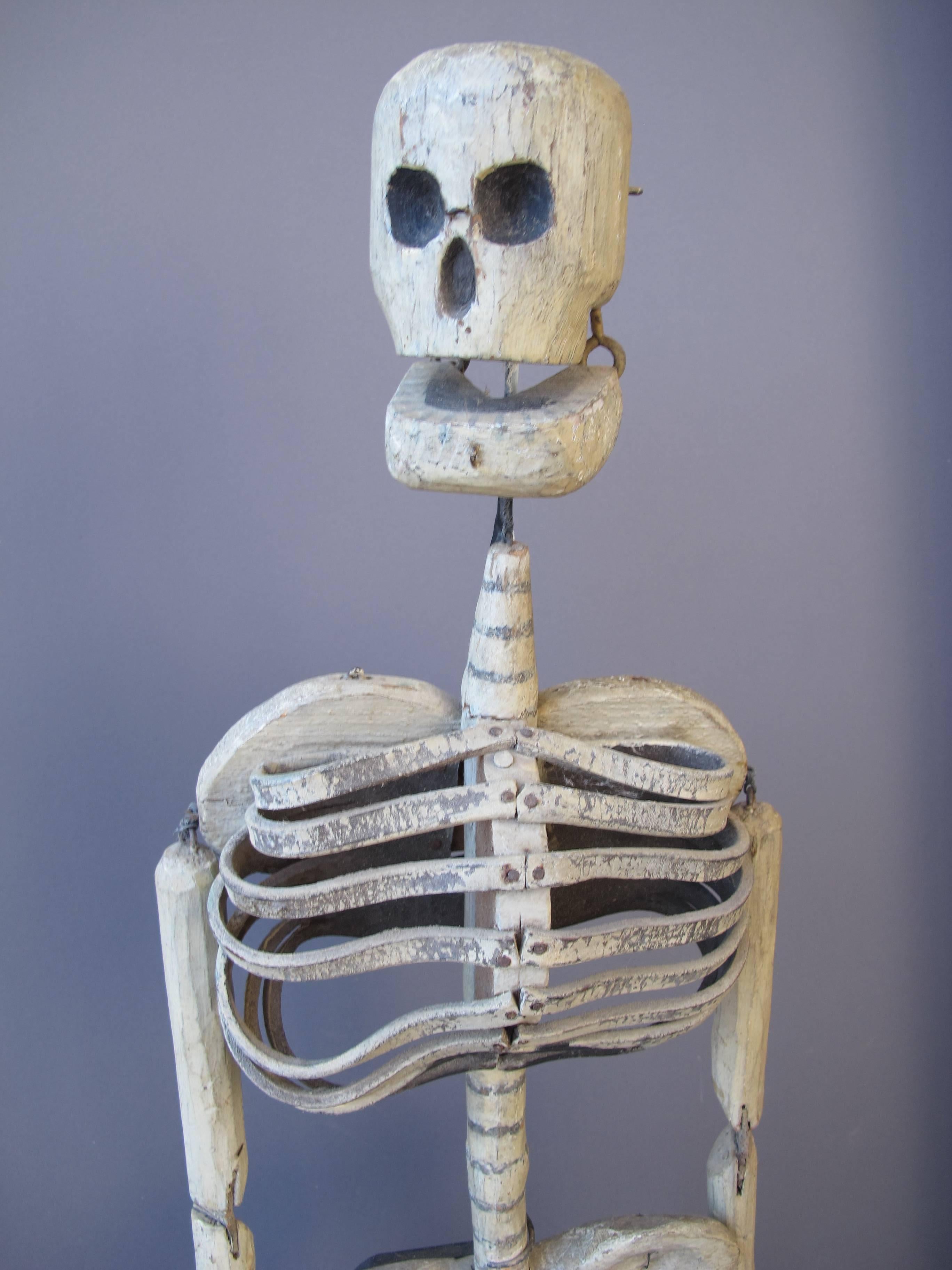 Carved and joined wooden puppet with curved leather for rib cage. This skeleton would be able to be animated or dance with attachment to various points. I was reported to have been used in an Odd Fellows Fraternal Lodge where skeletons were used as