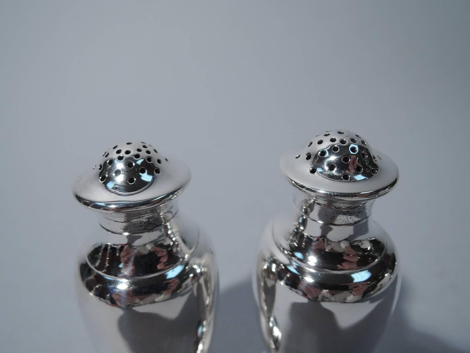 Pair of sterling silver salt and pepper shakers. Made by Tiffany & Co. in New York. Each: baluster on stepped foot. Pierced, domed, and detachable cover. Hallmark includes pattern no. 9122B and director's letter m (1907-47). Excellent