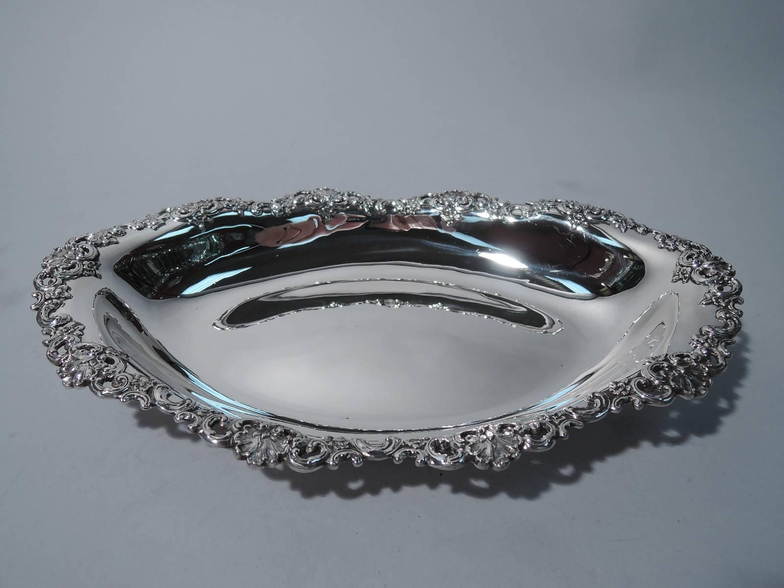 Sterling silver bread tray. Made by Tiffany & Co. in New York, circa 1895. Oval with tapering sides and pointed ends. Scallop shells and scrolls applied to rim. The pattern (no. 12344) was first produced in 1895. Hallmark includes director's letter
