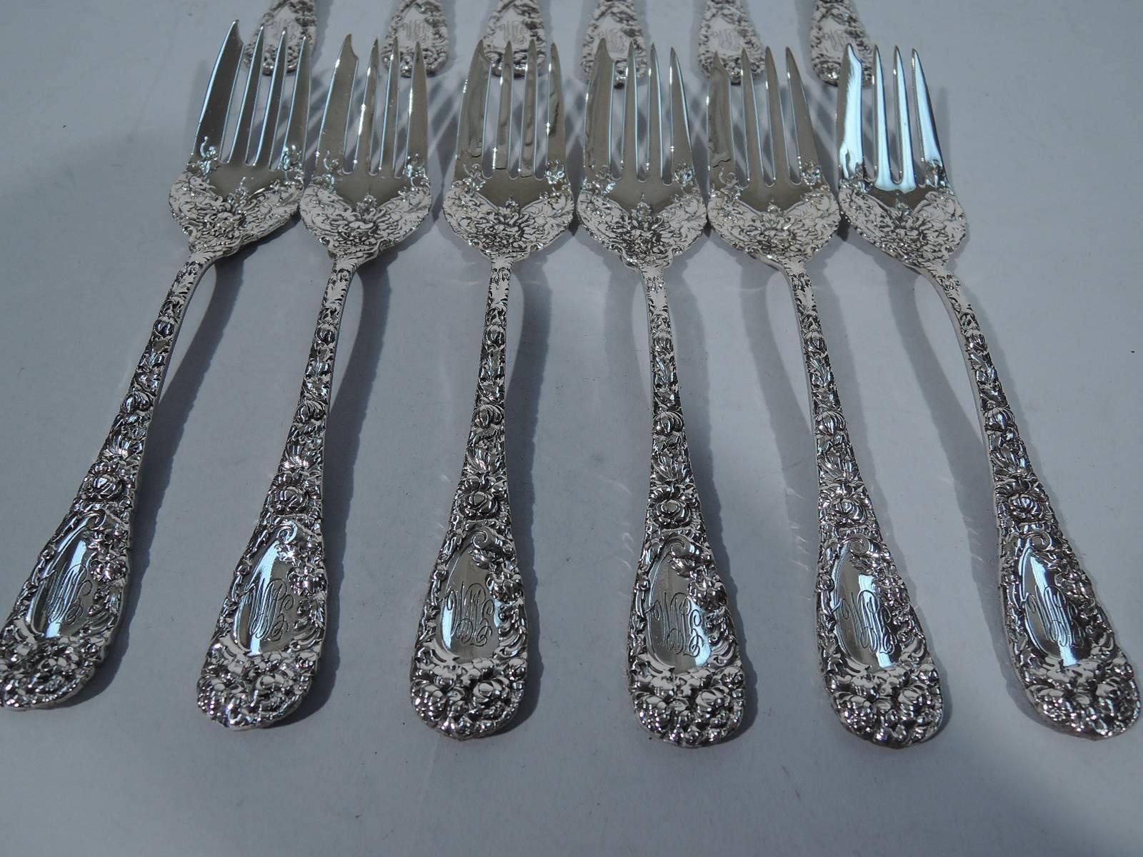 Set of 12 salad forks in Chrysanthemum pattern. Made by Durgin in providence. Curved shank with four tines. Dense low-relief flowers on front and back. Script monogram. Nice pieces in this Japanese-inspired pattern designed by George A. Muller and