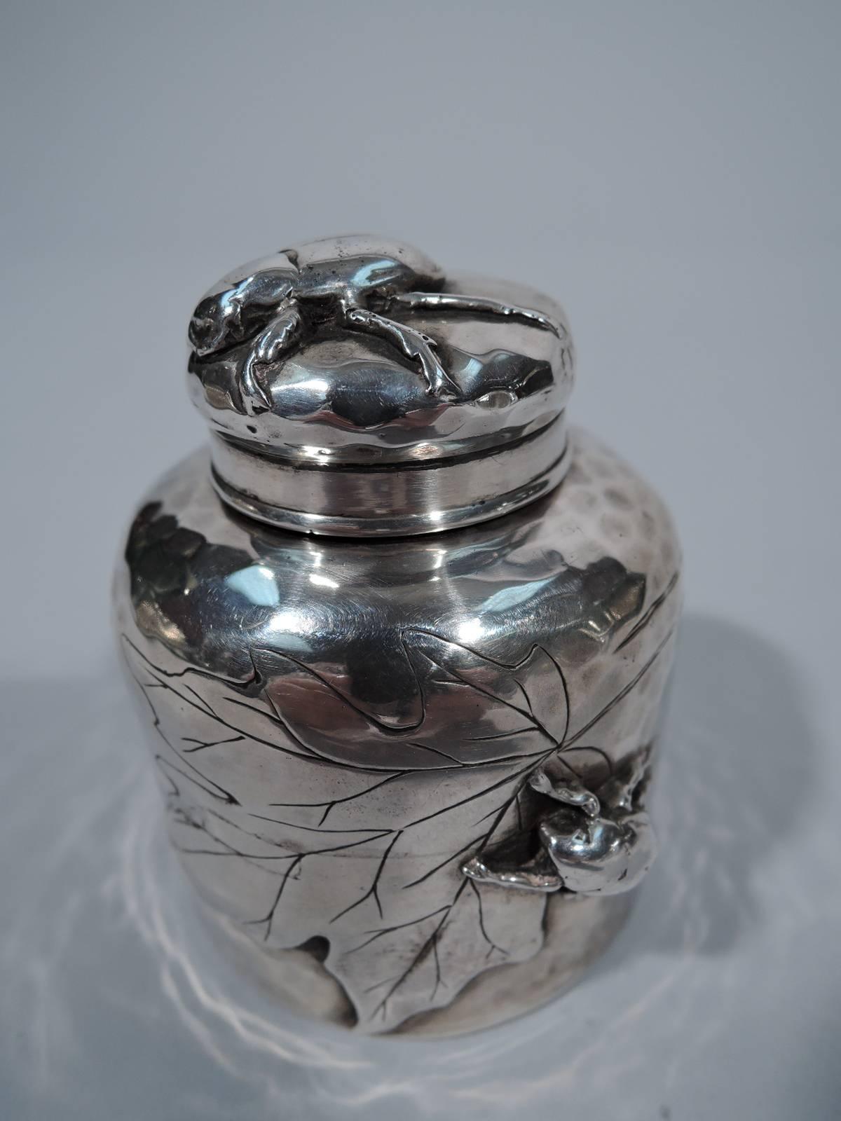 Hand-hammered and applied sterling silver inkwell. Made by Tiffany & Co. in New York, circa 1880.

Straight sides, curved shoulders, and threaded bun cover. A conventional form embellished with insects and leaves applied to honeycomb ground.