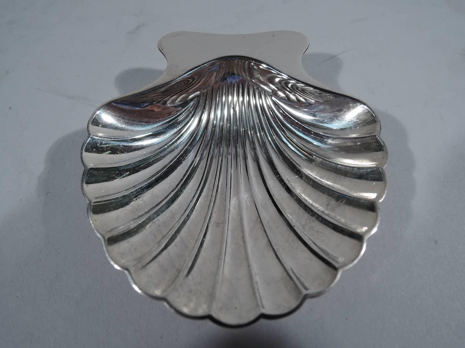 Set of ten sterling silver scallop shell nut dishes. Made by Tiffany & Co. in New York. Each: Dense flutes and plain handle. Rests on two balls. The pattern (no. 22479) was first produced in 1937. Hallmarked. Three shells have director’s letter m