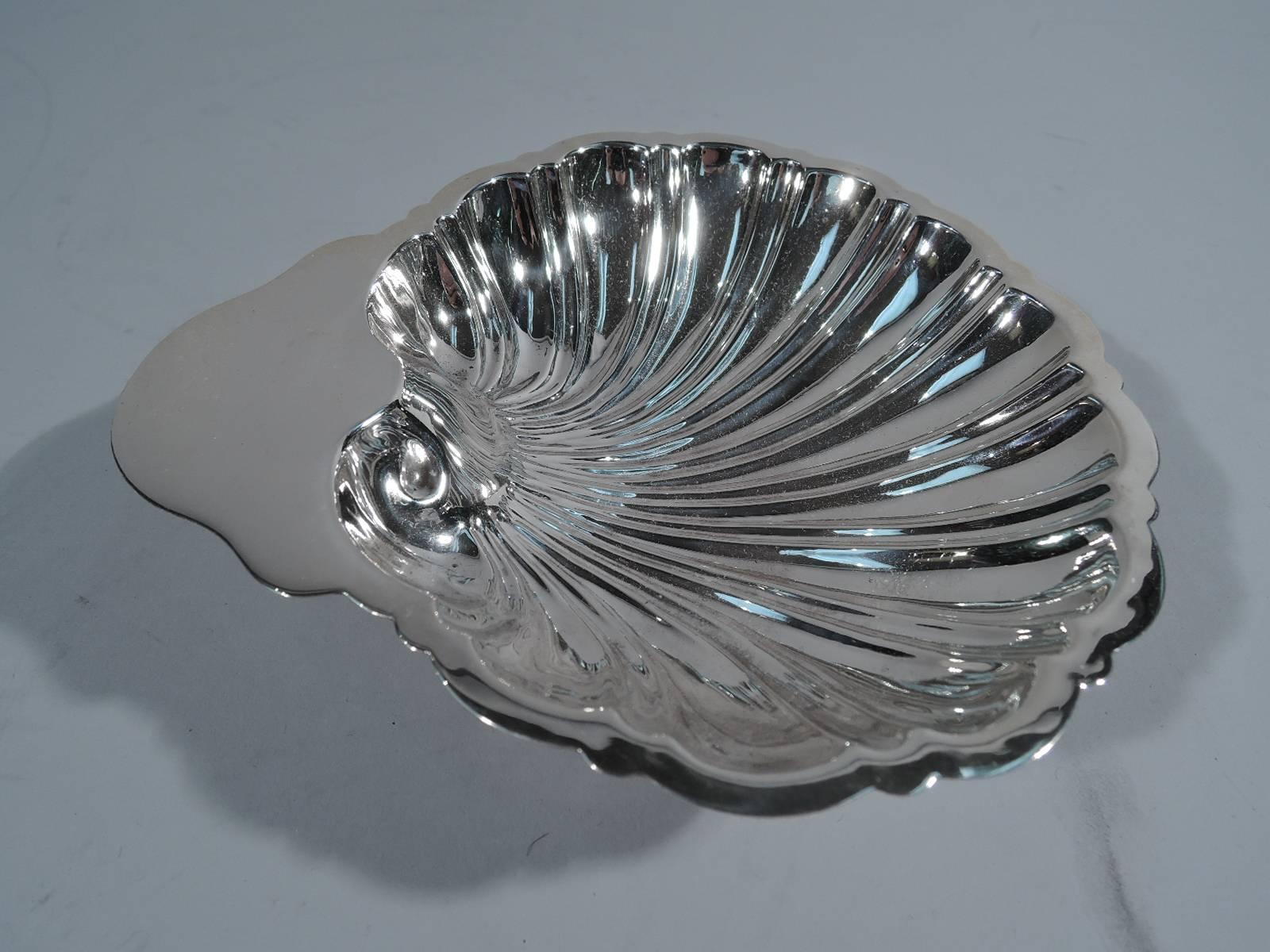 American sterling silver scallop shell dish. Retailed by Brand-Chatillon in New York, circa 1940. Fine and dynamic flutes and sold handle. Rests on three balls. Retailer’s mark and no. 180. Very faint hallmark appears to be for Revere Silver (a