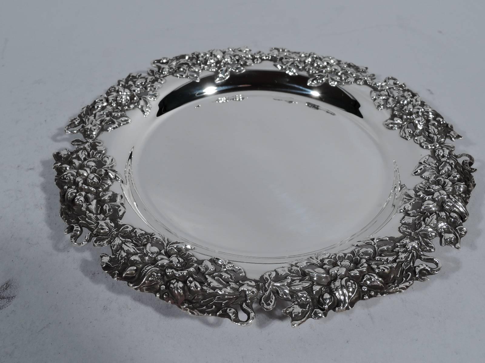 Pair of sterling silver wine bottle coasters. Made by Mauser in New York, circa 1900. Each: Circular plain well. Repousse floral rim applied to shoulder. Pretty and tactile. Hallmark includes no. 1091 and retailer’s name MS Cooler. 

Dimensions: H