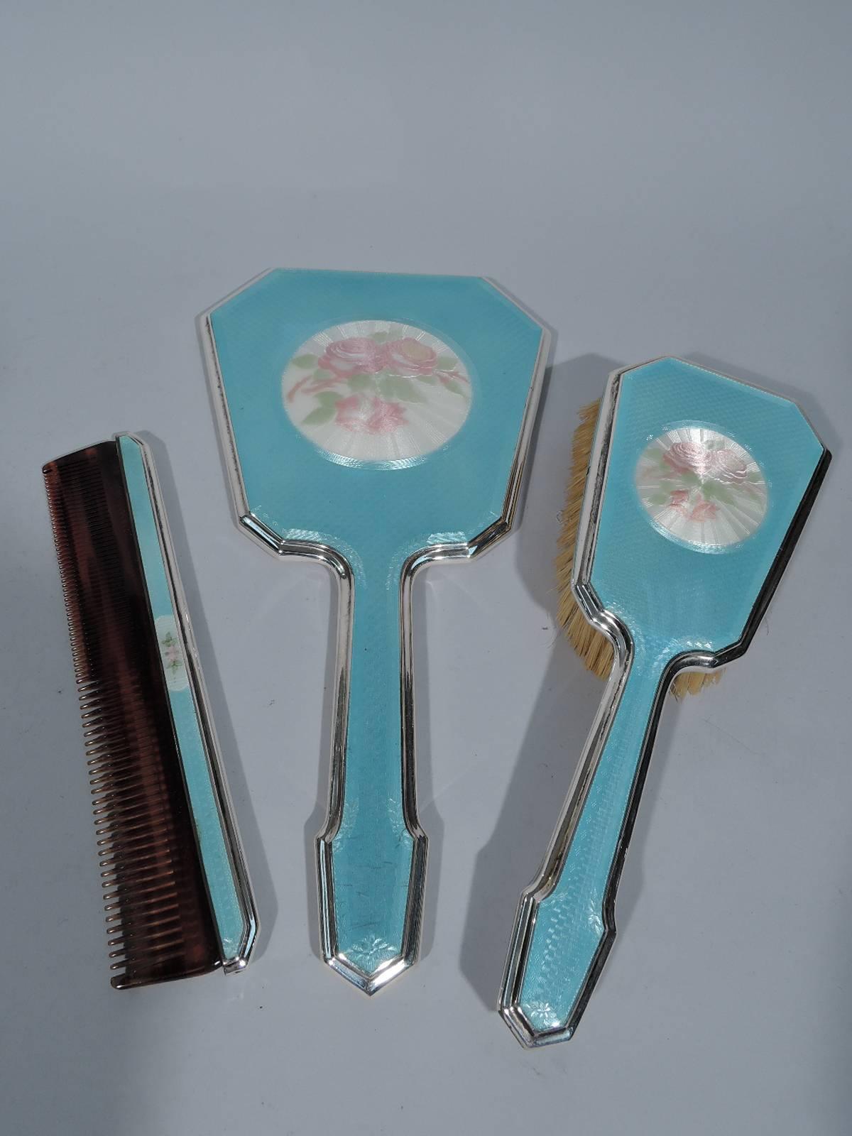 Pretty sterling silver, enamel, and glass vanity set. Made by Foster & Bailey in Providence, circa 1928. This set comprises hand mirror, hair brush, comb, powder jar, and rouge pot.

All: Pink roses in radiating white frame on blue guilloche