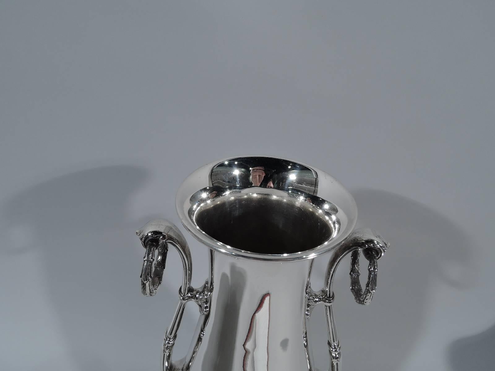 Tall and classical sterling silver trophy cup. Made by Gorham in Providence, circa 1910. Baluster body on domed foot. Leaf-capped and mounted s-scroll side handles with brackets and fixed laurel wreath rings. Unusual form with lots of room for