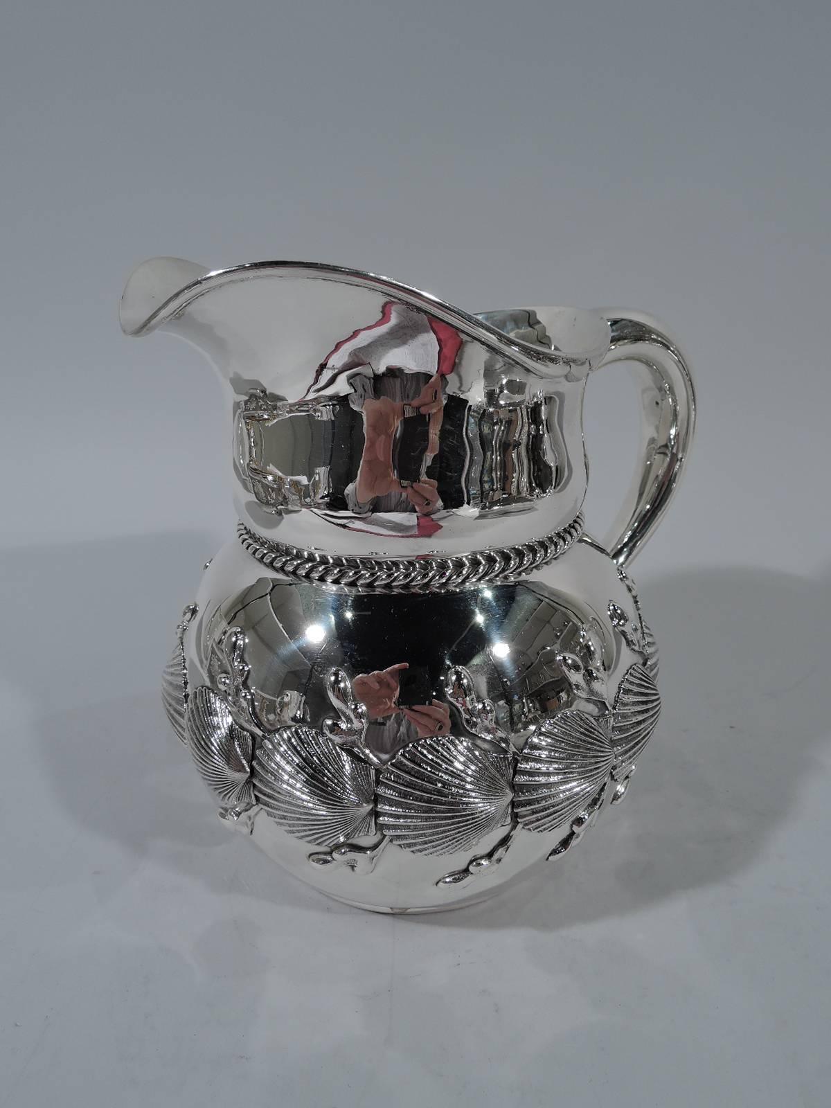 Wonderful marine sterling silver water pitcher. Made by Theodore B. Starr in New York, circa 1885. Globular with curved neck, helmet mouth, and c-scroll handle. Band of scallop shells and algae applied to body. Rope applied to neck base. A great