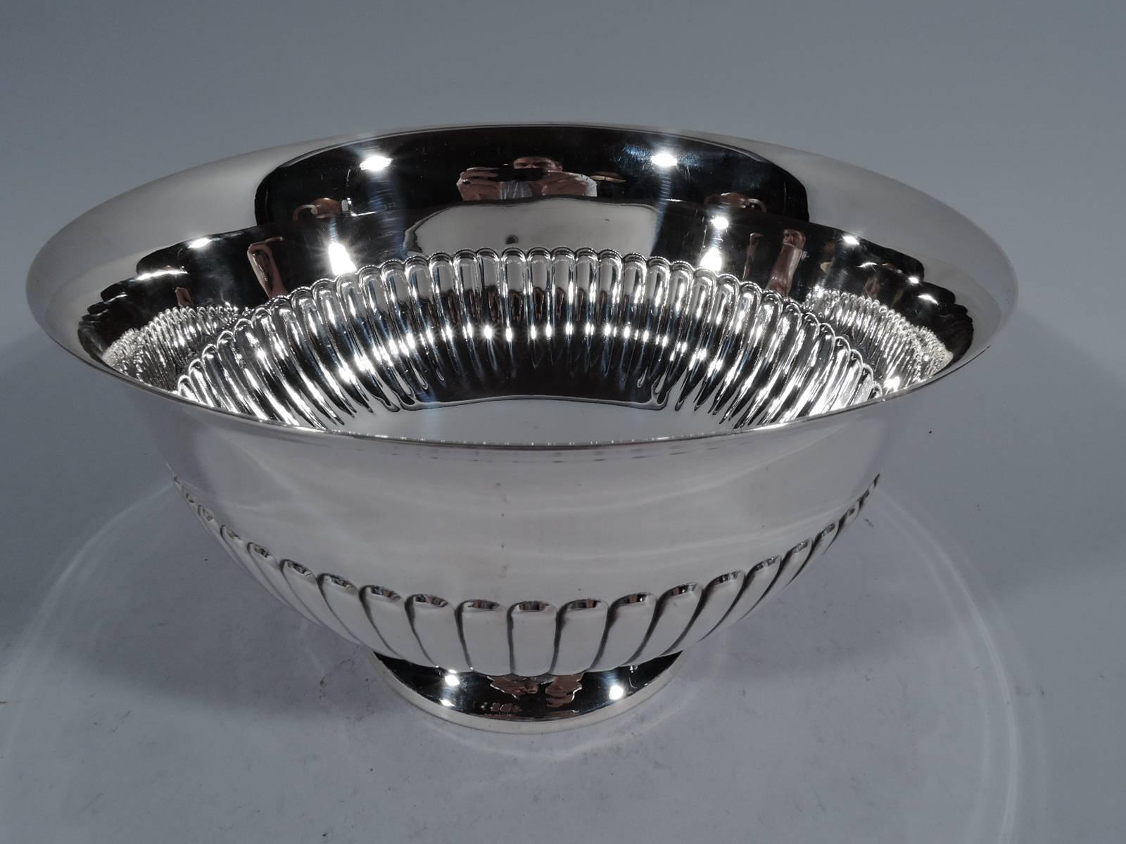 Classical sterling silver footed bowl. Made by Cartier in New York, circa 1940. Curved sides with flared rim and half gadrooning. Rests on stepped foot. Hallmark includes no. 232. Weight: 24.8 troy ounces.