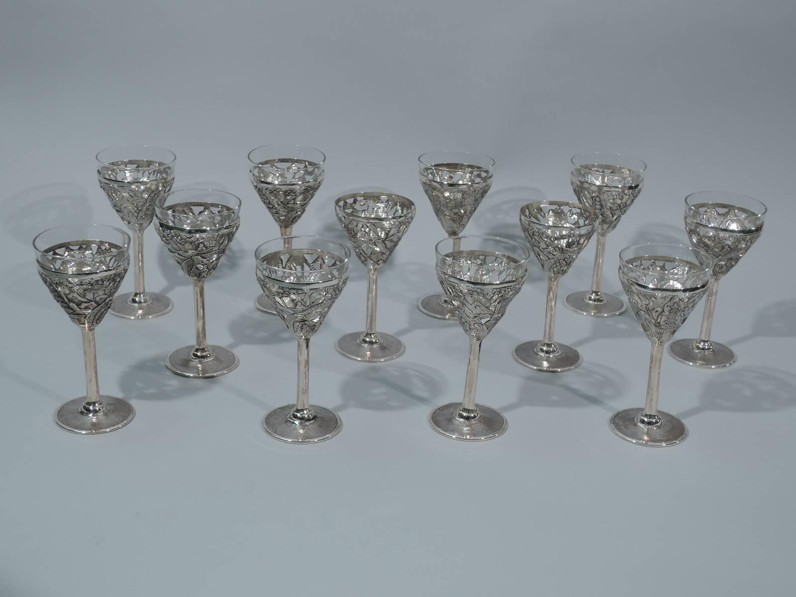 Set of ten Chinese export silver cocktail cups, circa 1910. Each: Pierced conical bowl, cylindrical stem, and flat circular foot. Bowl decorated with exotic pagodas, blossoming prunus branches, and rickshaw-pulling natives. Foot stippled. Clear
