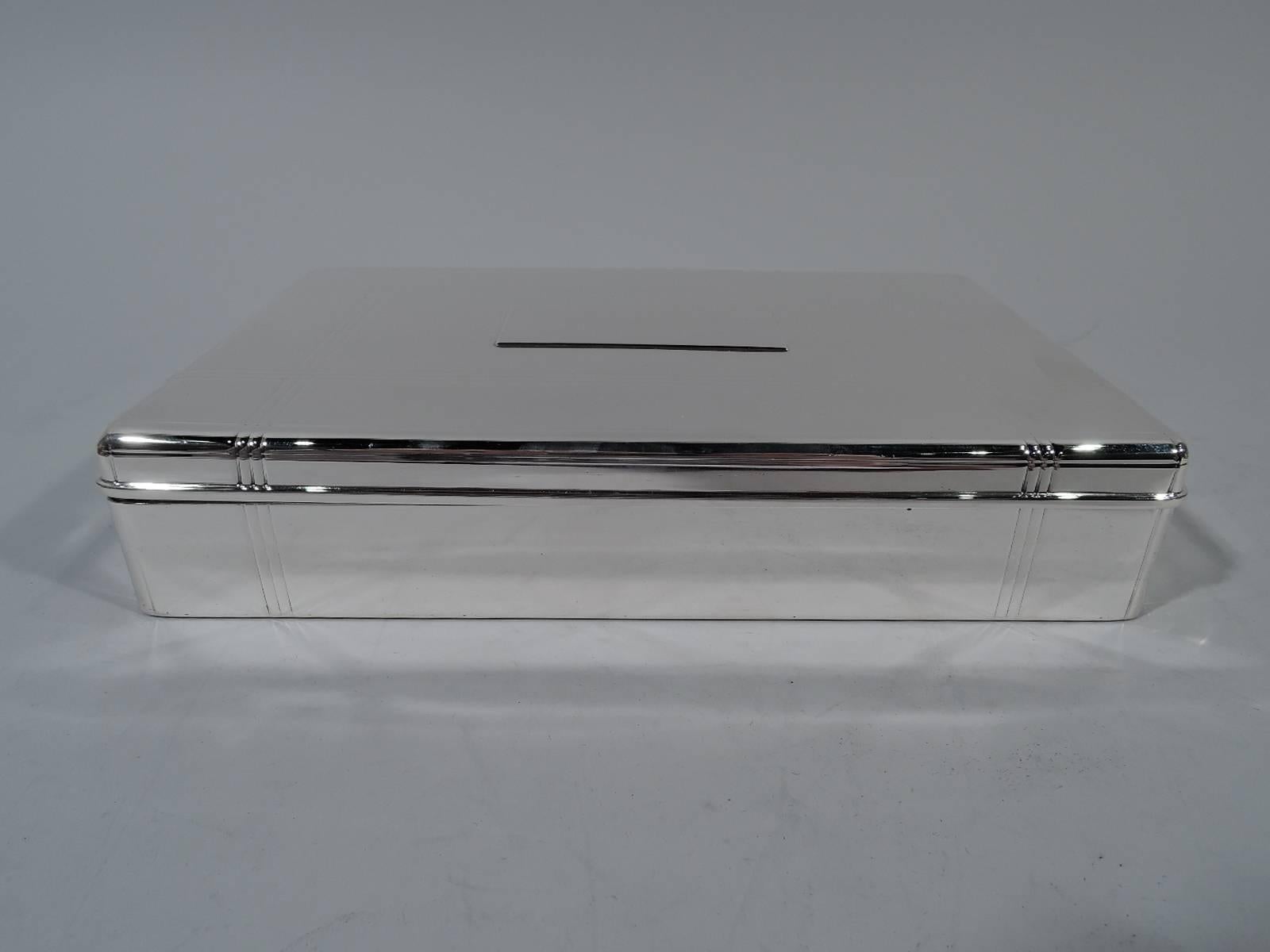 Art Deco sterling silver desk box. Made by Tiffany & Co. in New York, circa 1928. Rectangular with straight sides and curved corners. Cover hinged with molded rim. Cover has four intersecting linear bands that continue on sides. Rectangular tablet