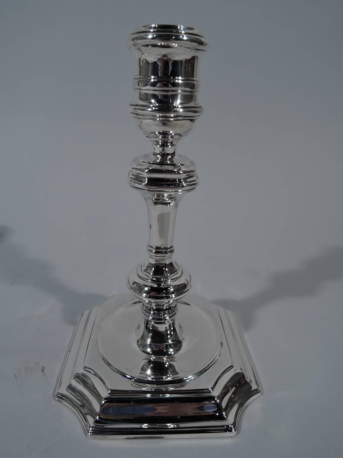 Pair of Georgian-style sterling silver candlesticks. Made by Tiffany & Co. in New York, circa 1915. Each: Spool socket, faceted and knopped shaft, and stepped square base with concave corners. Representative English style based on a design by