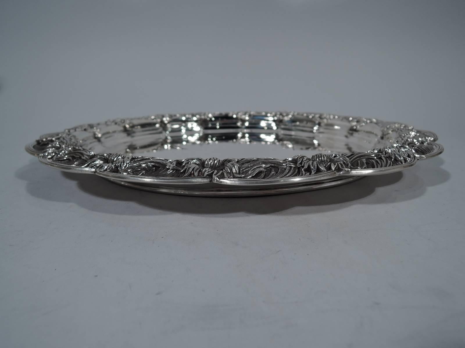 Wonderful sterling silver tray in Chrysanthemum pattern. Made by Tiffany & Co. in New York. Plain and circular well. Reeded and scalloped rim with applied overlapping chrysanthemums. A beautiful piece in this historic pattern. Hallmark includes