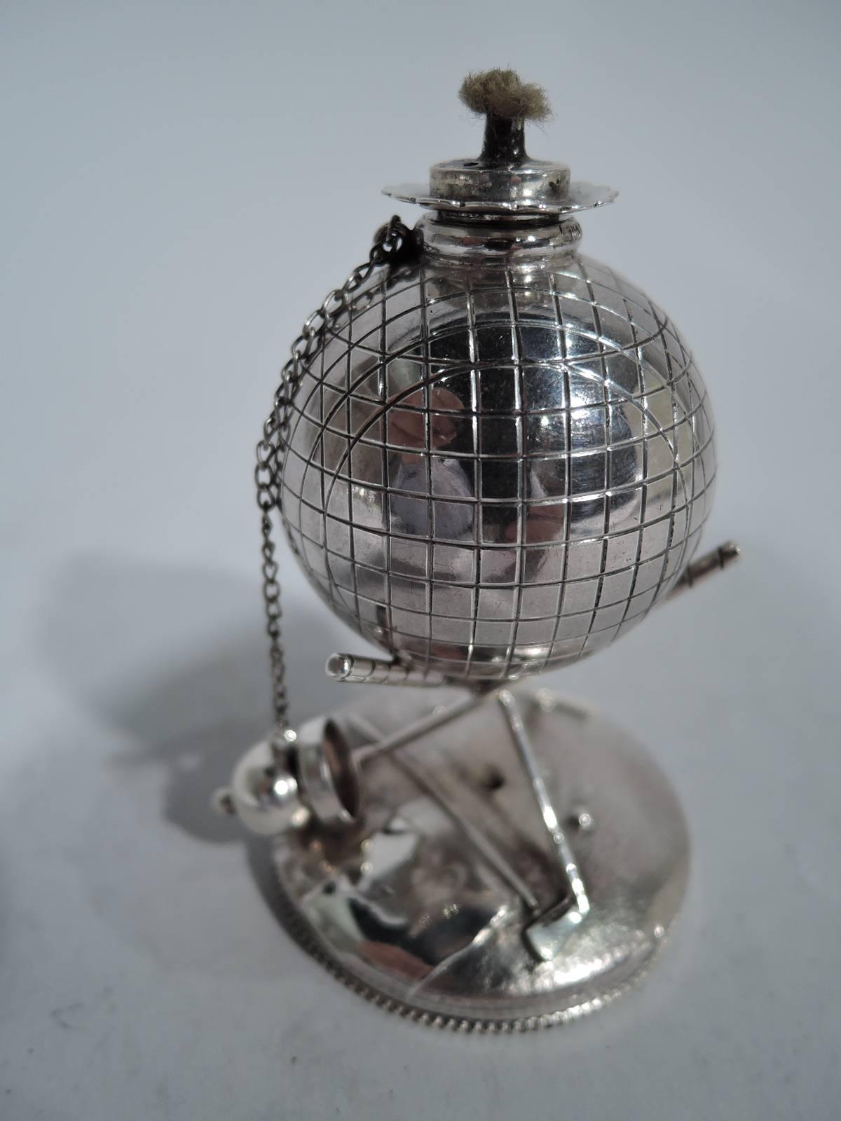 Sterling silver cigar lighter. Made by Reed & Barton in Taunton, Mass., circa 1920. Golf ball bowl with chained ball cover and threaded wick. Ball mounted to cradle comprising two crossed clubs mounted to raised and beaded circular base. An iconic
