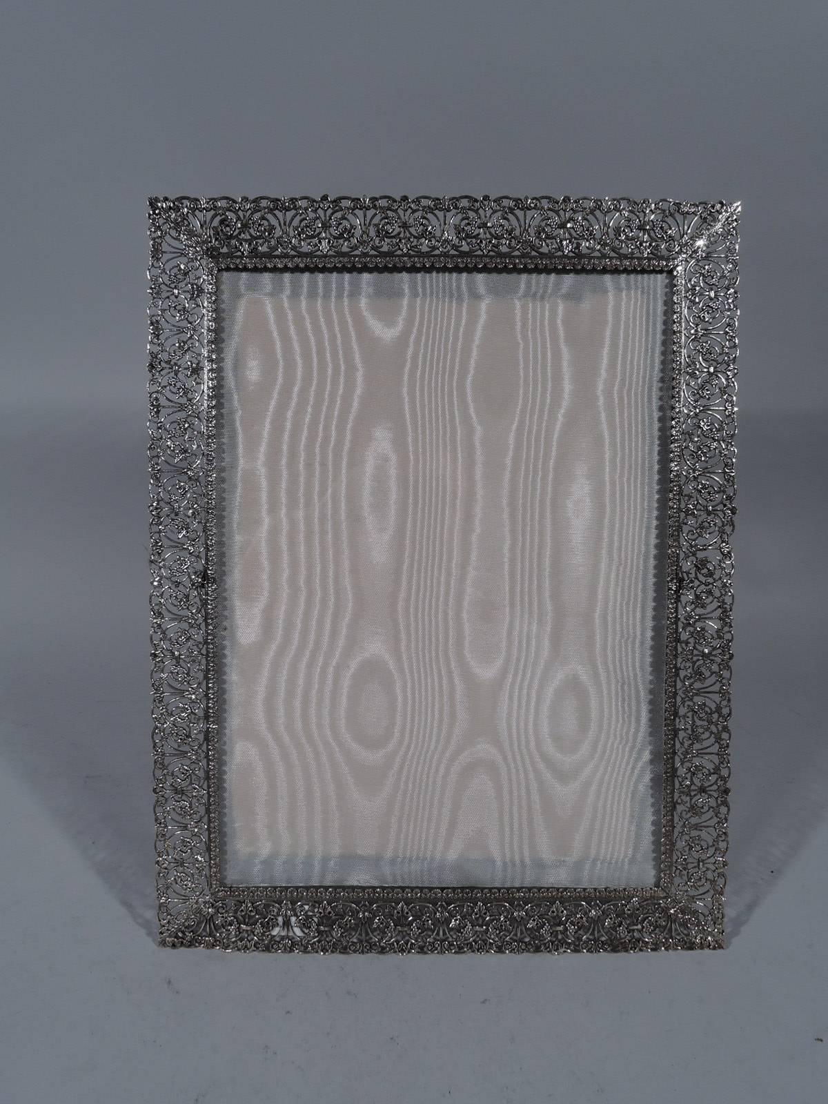 Italian handmade sterling silver filigree picture frame. Rectangular window bordered by scrolled filigree with applied flowers and leaves. With glass, silk lining, and velvet back and hinged support. For portrait (vertical) or landscape (horizontal)