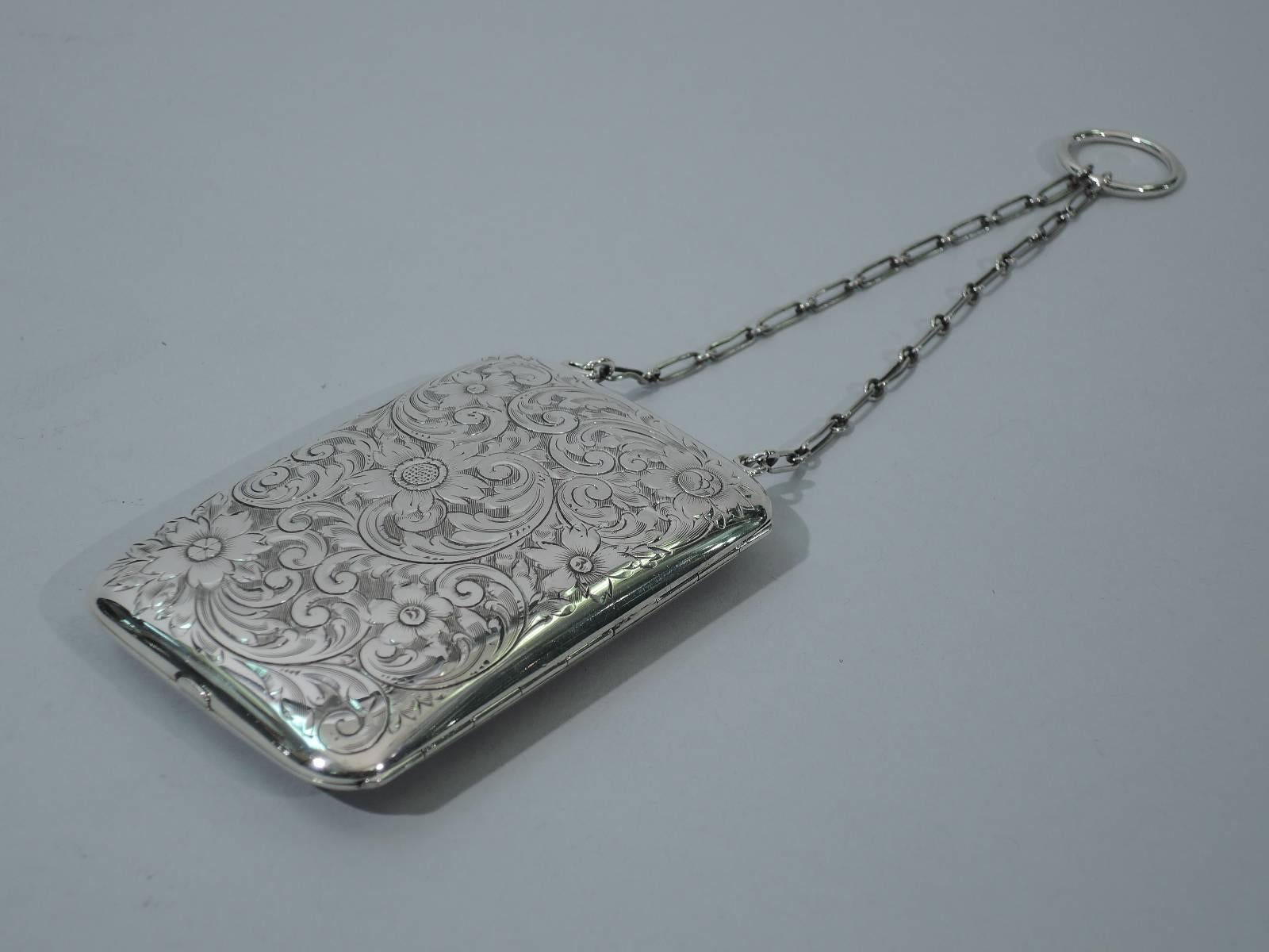 Sterling silver lady’s compact purse. Made by Theodore W. Foster (formerly Foster & Bailey) in Providence, circa 1910. Rectangular and hinged. all-over acid-etched scrolls and flowers. Compact interior with three compartments. With wrist chain and