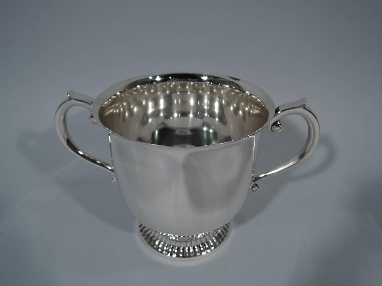 Classic sterling silver trophy cup. Made by Tiffany & Co. in New York, circa 1965. Urn with flared rim, capped scroll side handles, and raised and gadrooned foot. Good heft and lots of room for engraving. Hallmarked. Heavy weight: 34.2 troy ounces.