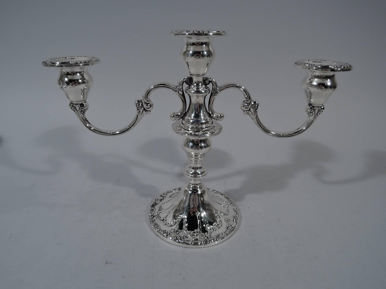 A charming pair of sterling silver three-light low candelabra in Chantilly pattern. Made by Gorham in Providence. Each: Central socket with two mounted s-scroll arms, each terminating in single socket. Ornate scrollwork applied to bobeches and base.