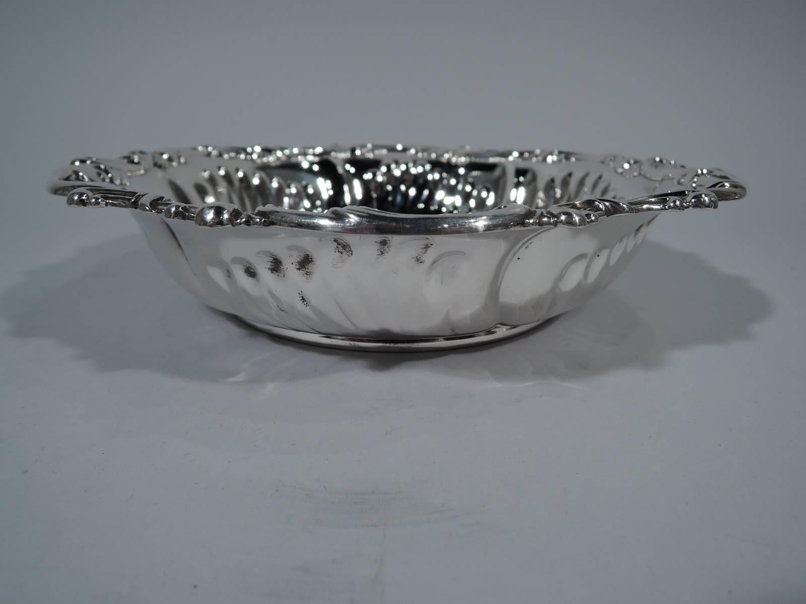 Sterling silver bowl. Made by Whiting in New York, circa 1900. Curved sides with twisted fluting and overlapping c-scrolls on rim. Foot ring. A pretty piece with nice heft. Hallmark includes no. 3999. Heavy weight: 15 troy ounces.