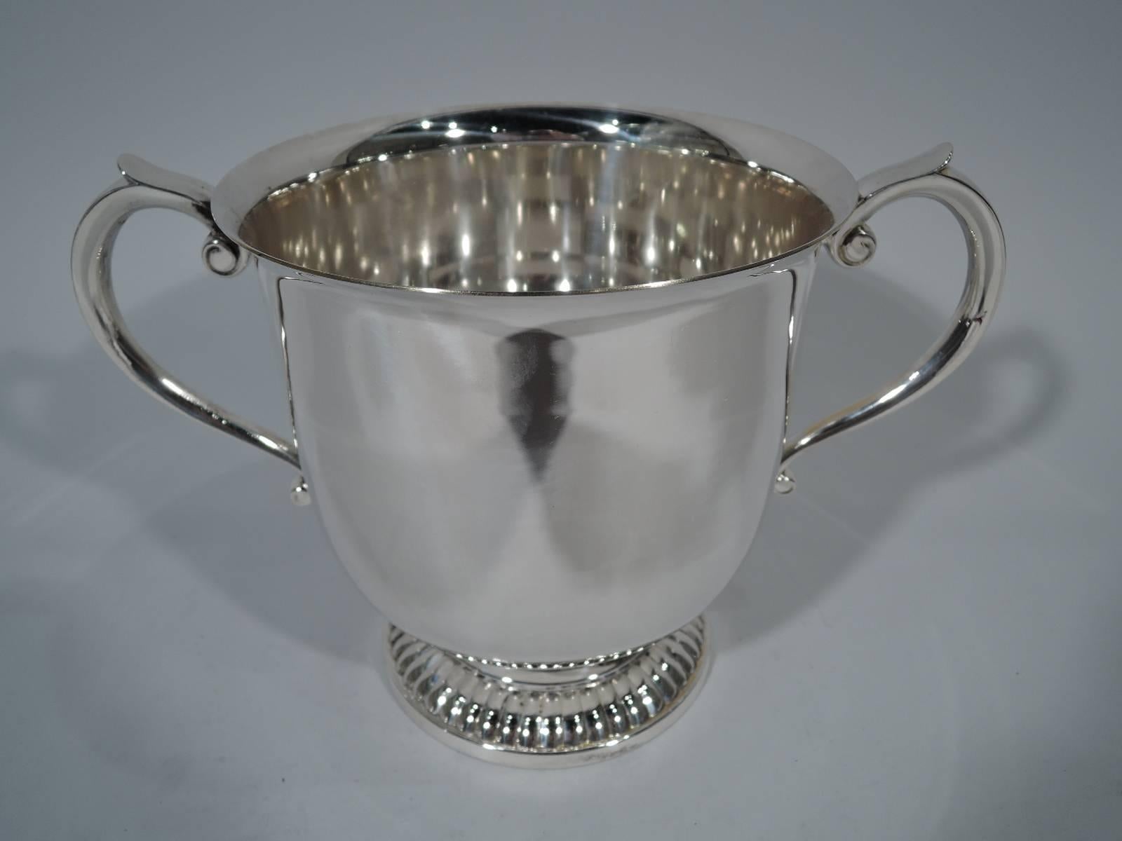 American sterling silver trophy cup. Urn with flared rim, capped scroll side handles and raised and gadrooned foot. Enough room for many years of winners’ names. Hallmarked Kirk Stieff. The two Baltimore silver makers merged in 1979 to form one