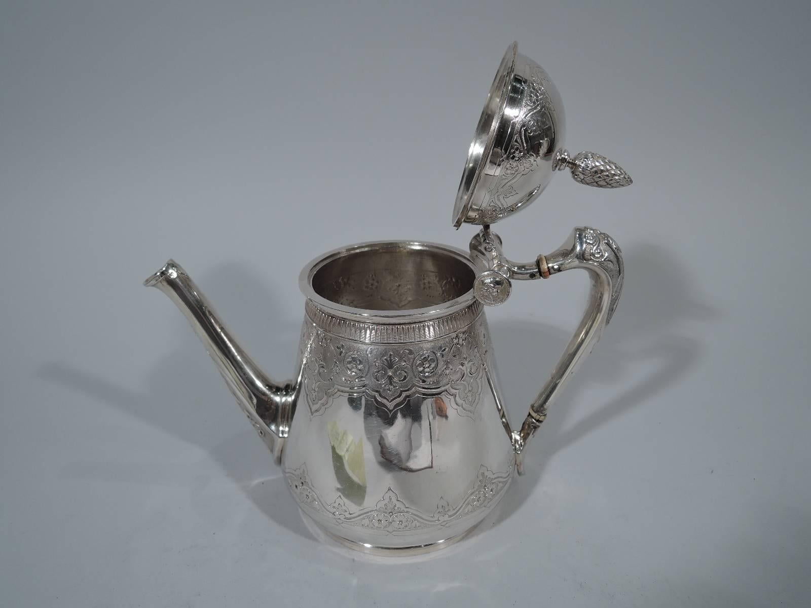 Aesthetic coin silver teapot. Made by Gorham in Providence, circa 1865. Upward tapering sides with curved base and short foot. Diagonal spout, scroll handle, and hinged dome cover with berry finial. Stylized ornament. Engraved frames with flowers on