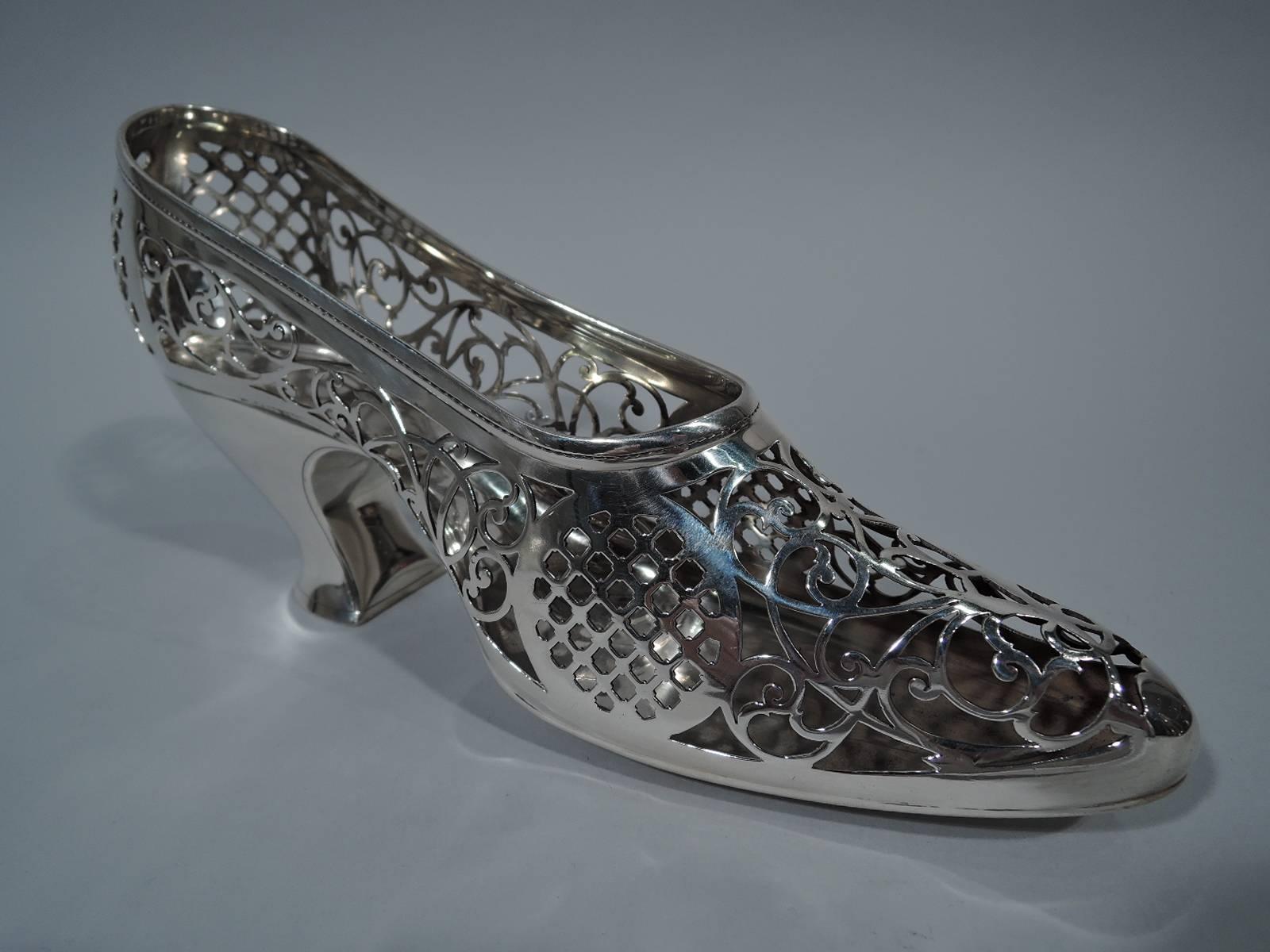 Edwardian sterling silver lady’s shoe. Made by Gorham in Providence, circa 1910. Pierced scrollwork and diaper as well as “stitched” seams. Sole and heel plain. An elegant boudoir accessory. Hallmark includes no. A5372. Weight: 9 troy ounces.