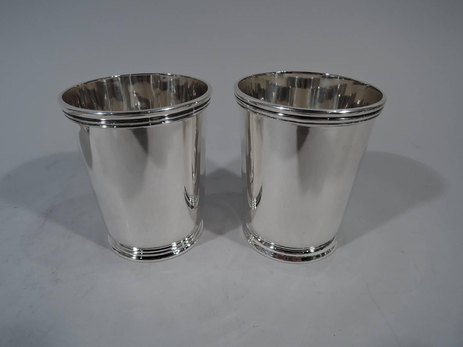 Set of four sterling silver mint julep cups. Made by R. Wallace & Sons Mfg. Co. in Wallingford, Conn. Each: Tapering sides with reeded rim and skirted foot. Hallmark includes no. 450. Heavy total weight: 20.2 troy ounces.