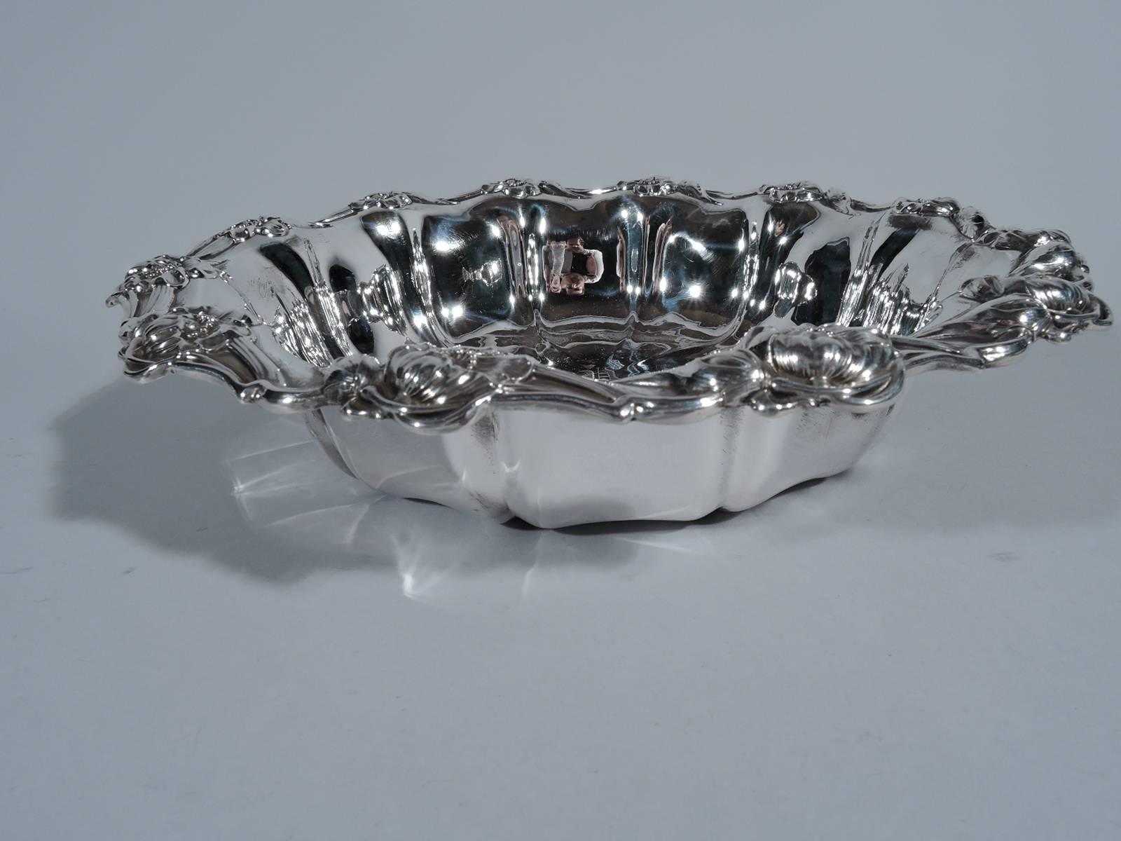 Art Nouveau sterling silver bowl. Made by Unger Brothers in Newark. Round with lobed sides. Well has raised radiating lines. Scrolled rim with tendrils, buds, and blossoms. Script monogram. A pretty piece by a collectible maker active in the late