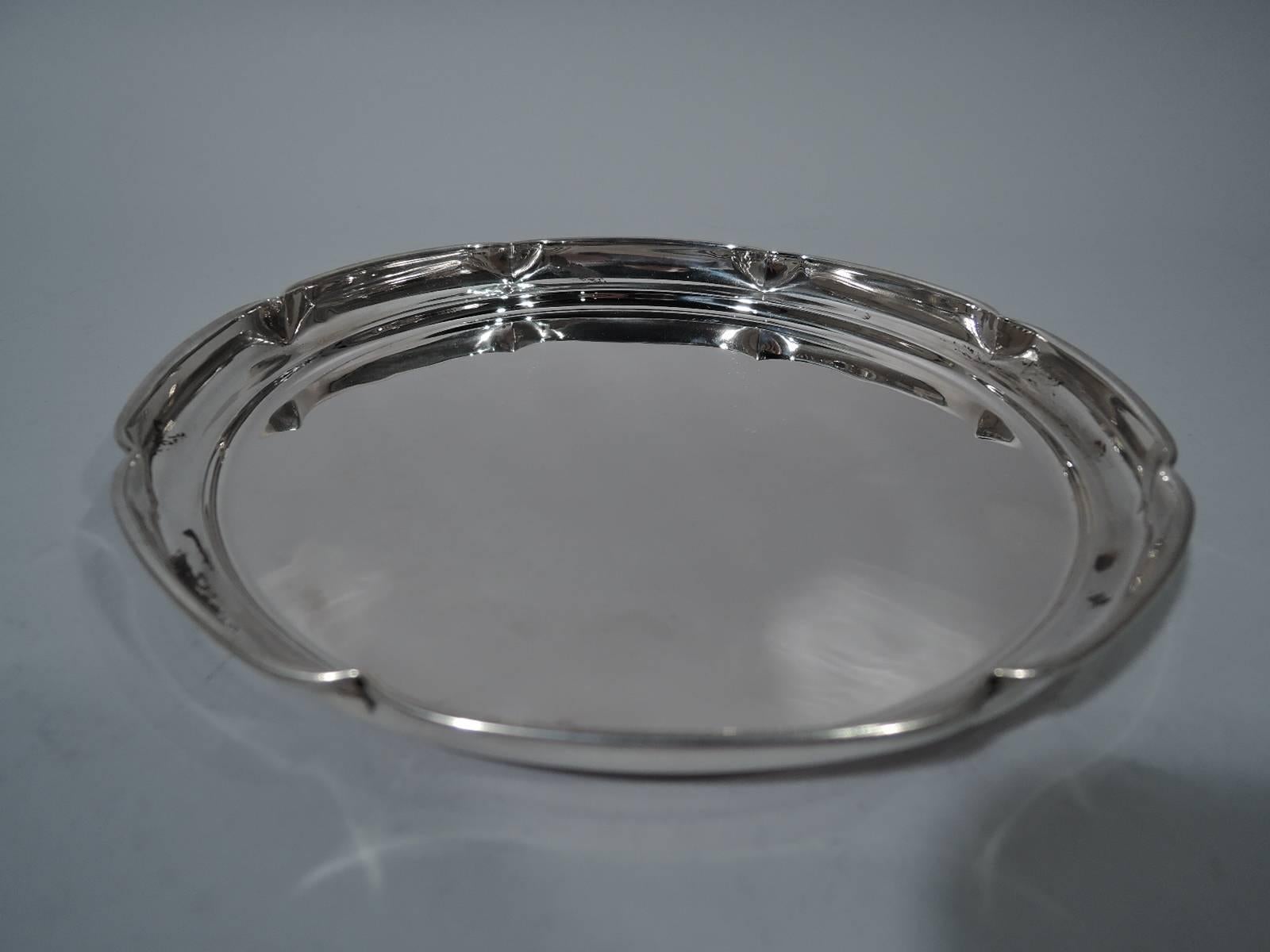 Sterling silver serving tray. Retailed by Cartier in New York, circa 1940. Circular with curved sides and molded and crimped (or lobed) rim. Hallmark includes no. 45/3. Weight: 6.3 troy ounces.