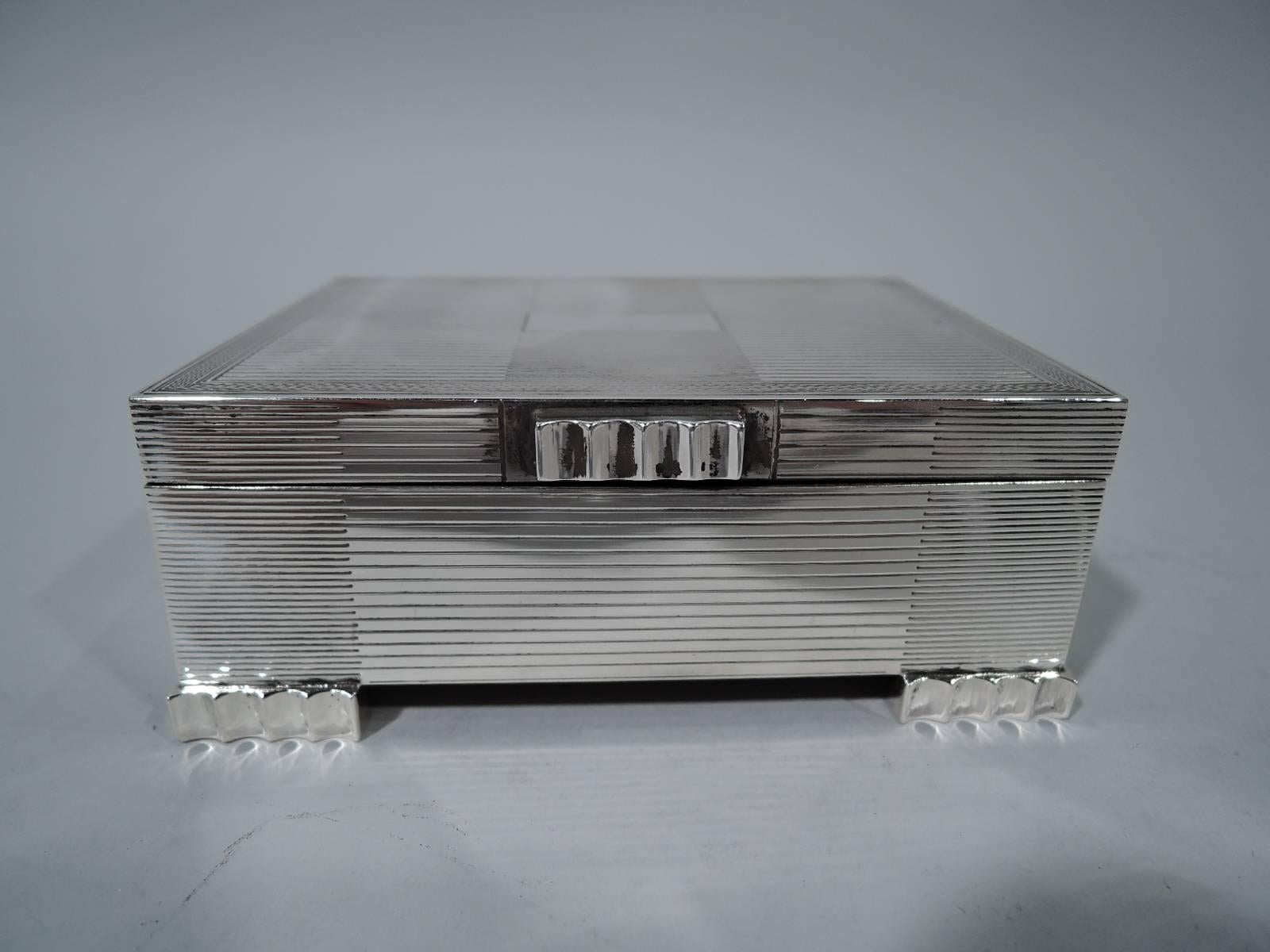 Snazzy sterling silver box. Made by John B. Chatterley & Sons in Birmingham in 1953. Rectangular with straight sides and flat hinged cover. Fluted corner bracket supports and tab. Engraved linear ornament. Cover has wavy border and central
