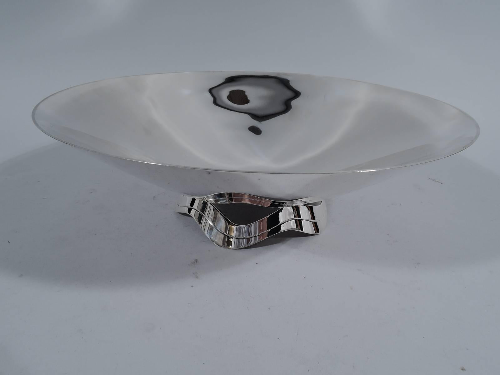 Mid-Century Modern sterling silver centrepiece bowl. Made by Tiffany & Co. in New York. Shallow bowl mounted to scrolled and open ribbon support. The support is reflected in the bowl - a witty example of reflection as a design element. Hallmark