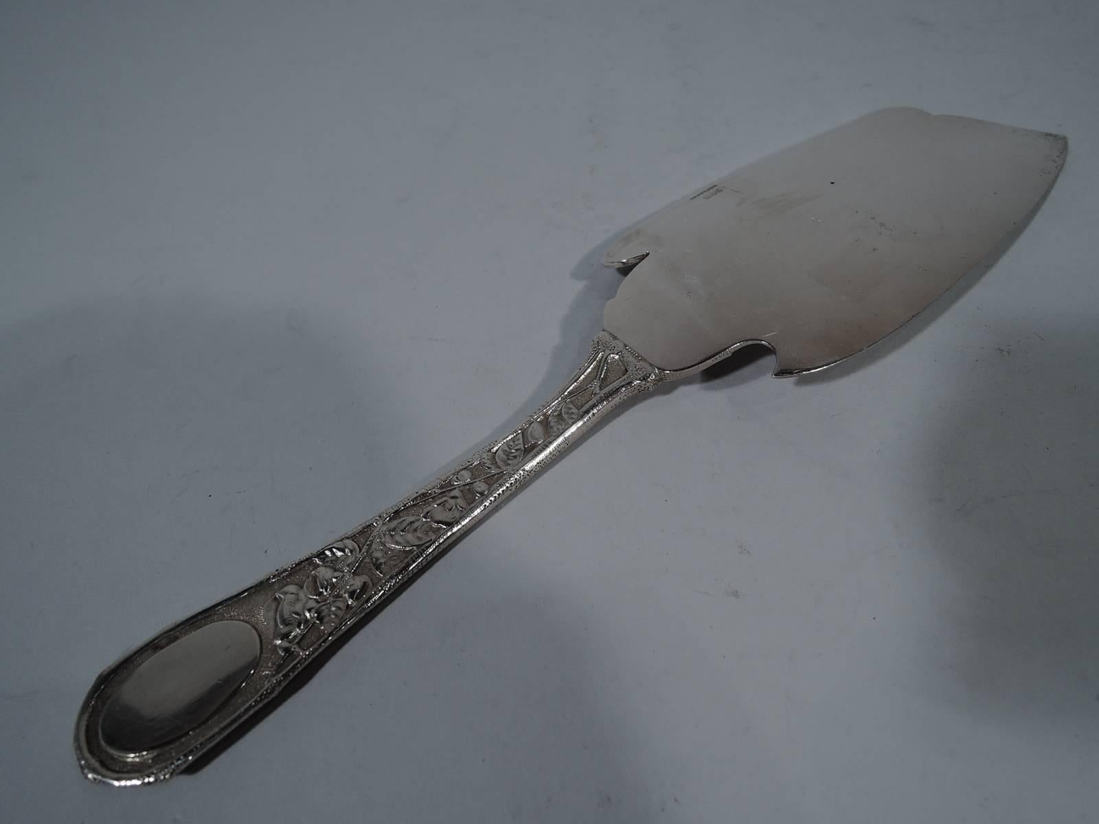 Antique sterling silver fish slice in Eglantine pattern. Made by Gorham in Providence. Dense repousse flowers and oval frame (vacant) on back. Shaped blade with engraved flowers. A nice piece in this early pattern, which was first produced in 1870.